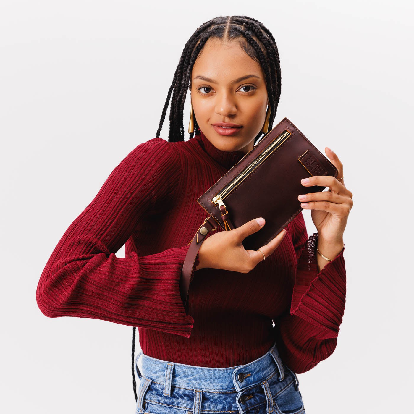 Cognac | Model holding flat leather pouch with zipper and wristlet