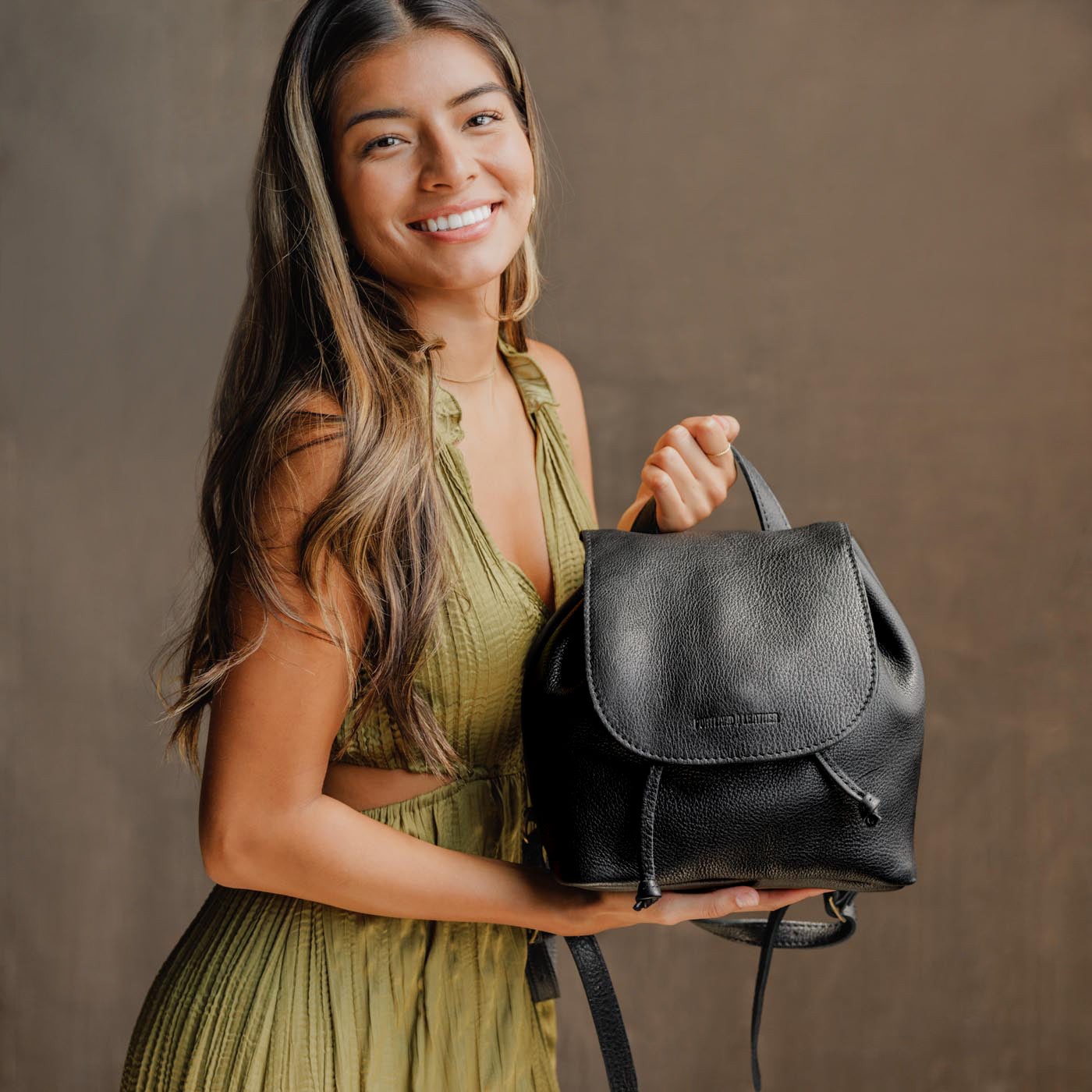 All Color: Pebbled--black | Model holding slouchy leather bucket backpack