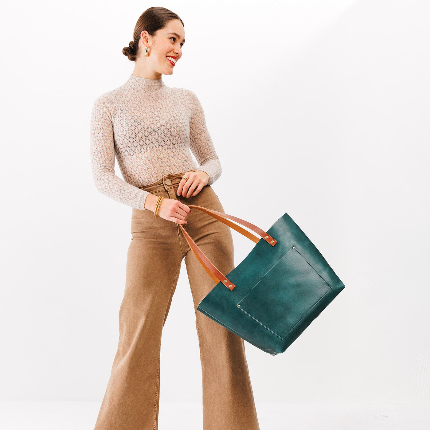 Caribbean*Classic| Model holding large leather tote bag with sturdy bridle handles and front pocket