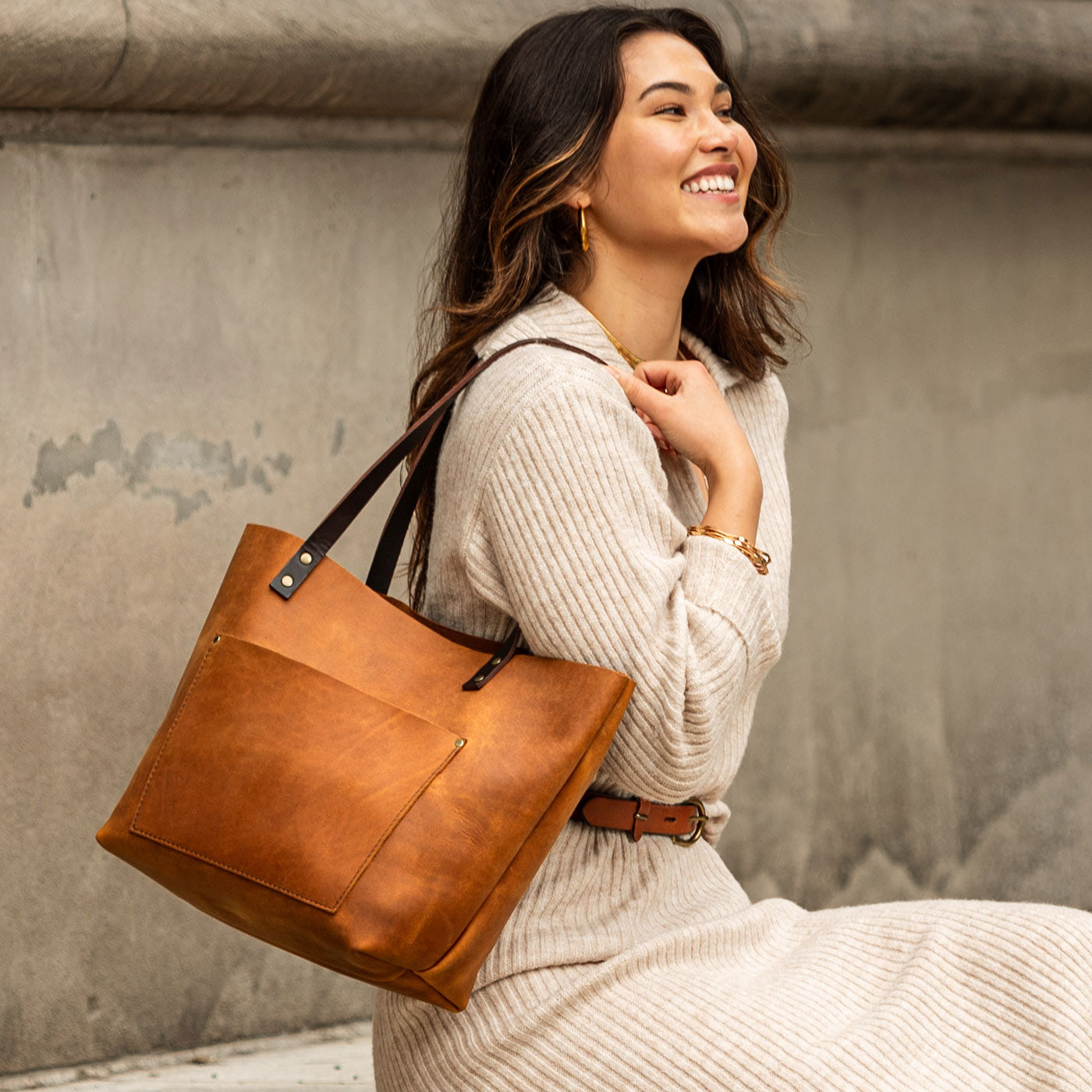 Dakota  | Model holding large leather tote bag with sturdy bridle handles and front pocket