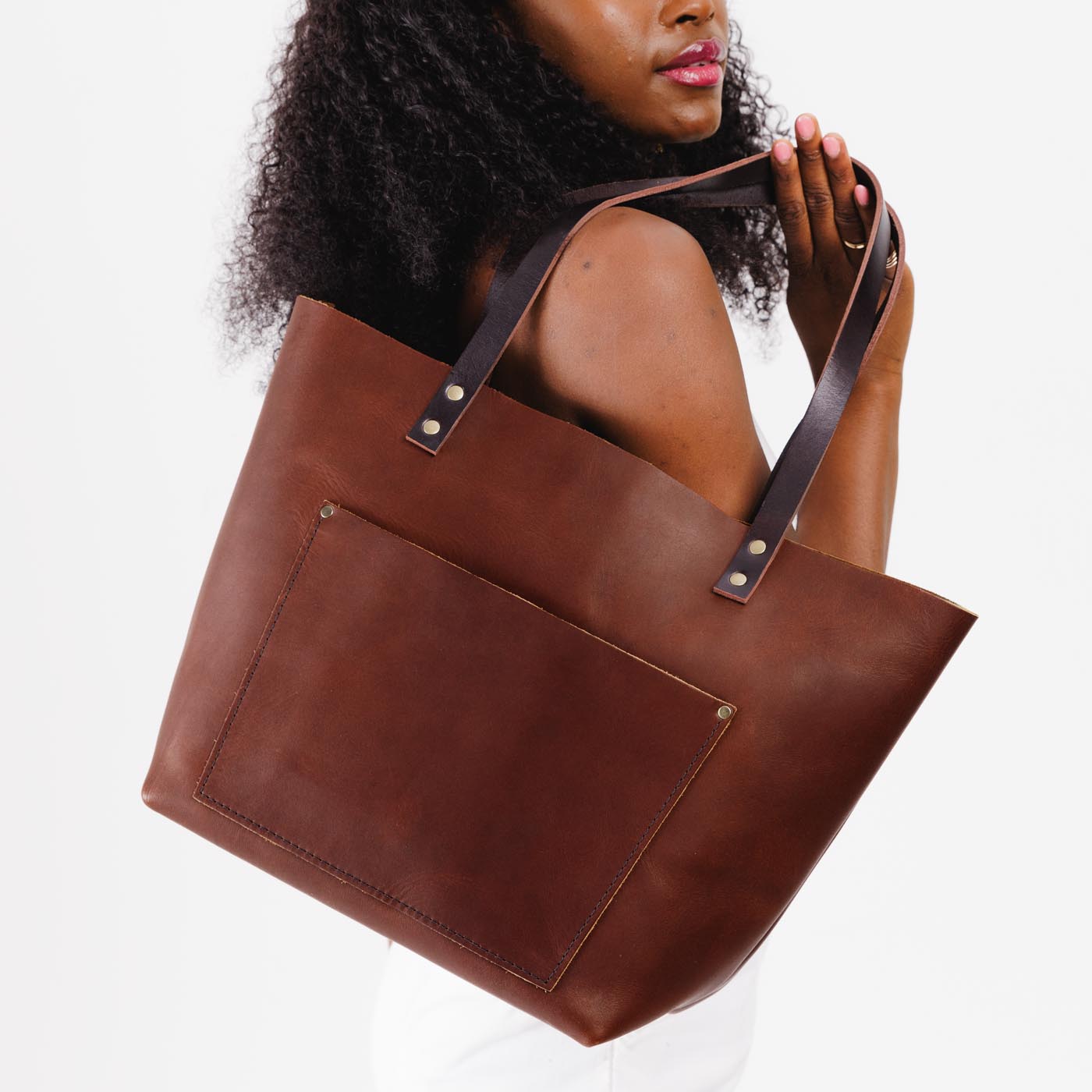 Durango*Classic | Model holding large leather tote bag with sturdy bridle handles and front pocket