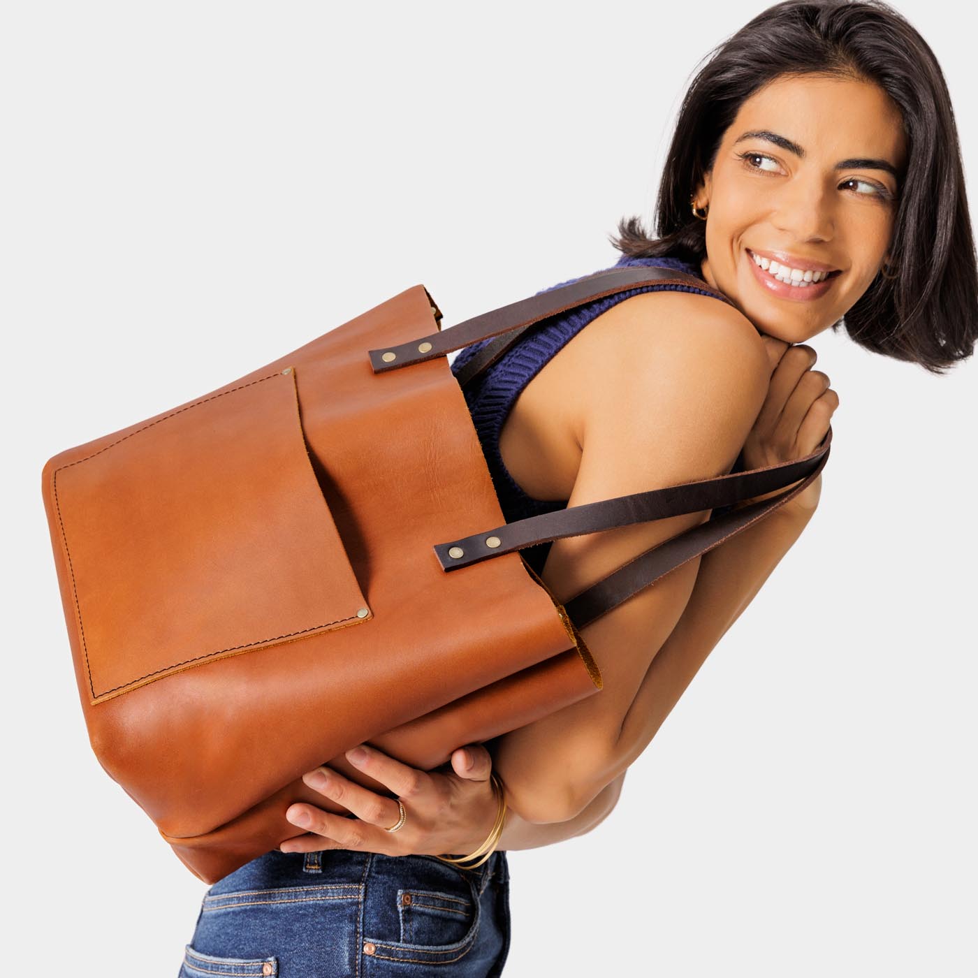 Honey Classic | Model holding large leather tote bag with sturdy bridle handles and front pocket