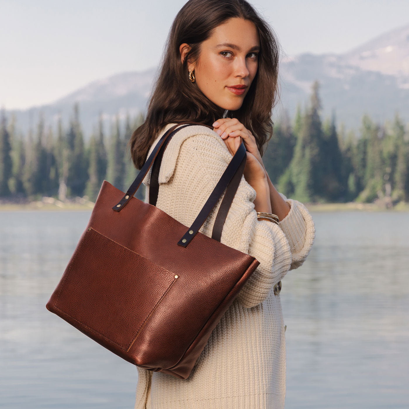 Nutmeg Classic  | Model holding large leather tote bag with sturdy bridle handles and front pocket