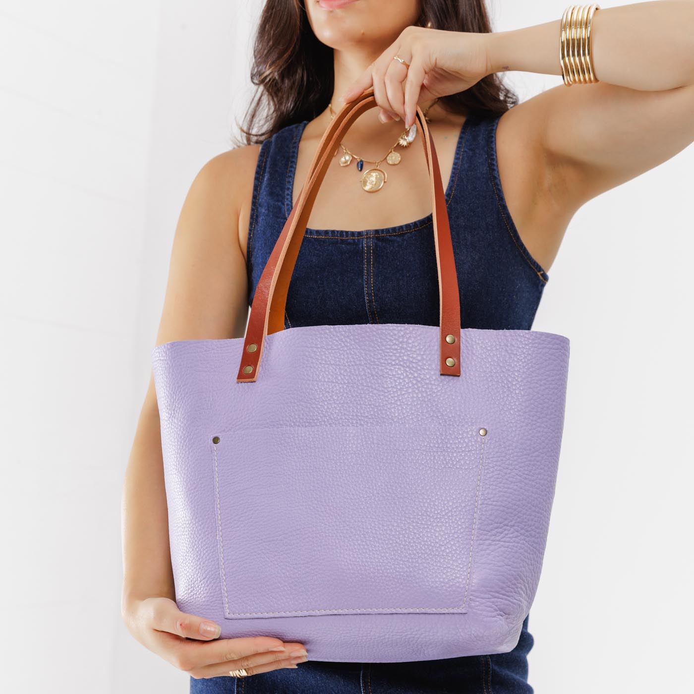 Wisteria*Classic | Model holding large leather tote bag with sturdy bridle handles and front pocket