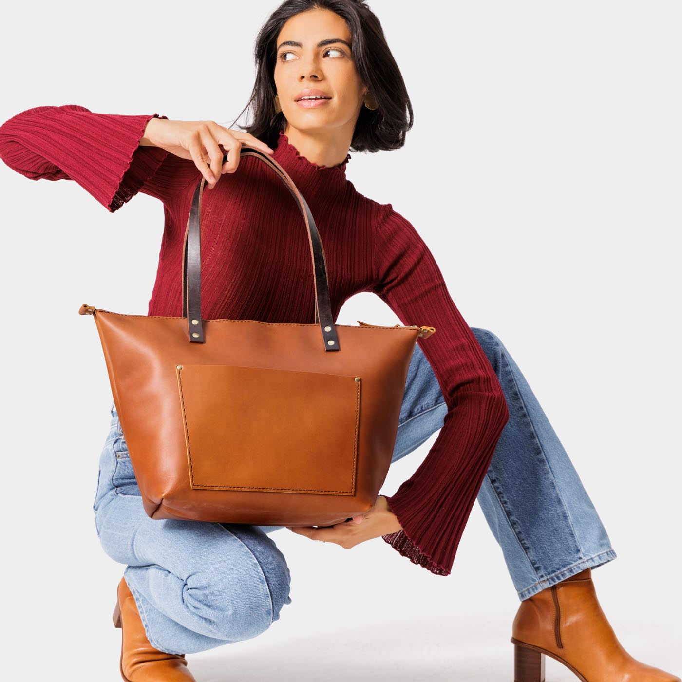 Honey*Zipper | Model holding large zipper leather tote bag with sturdy bridle handles and front pocket