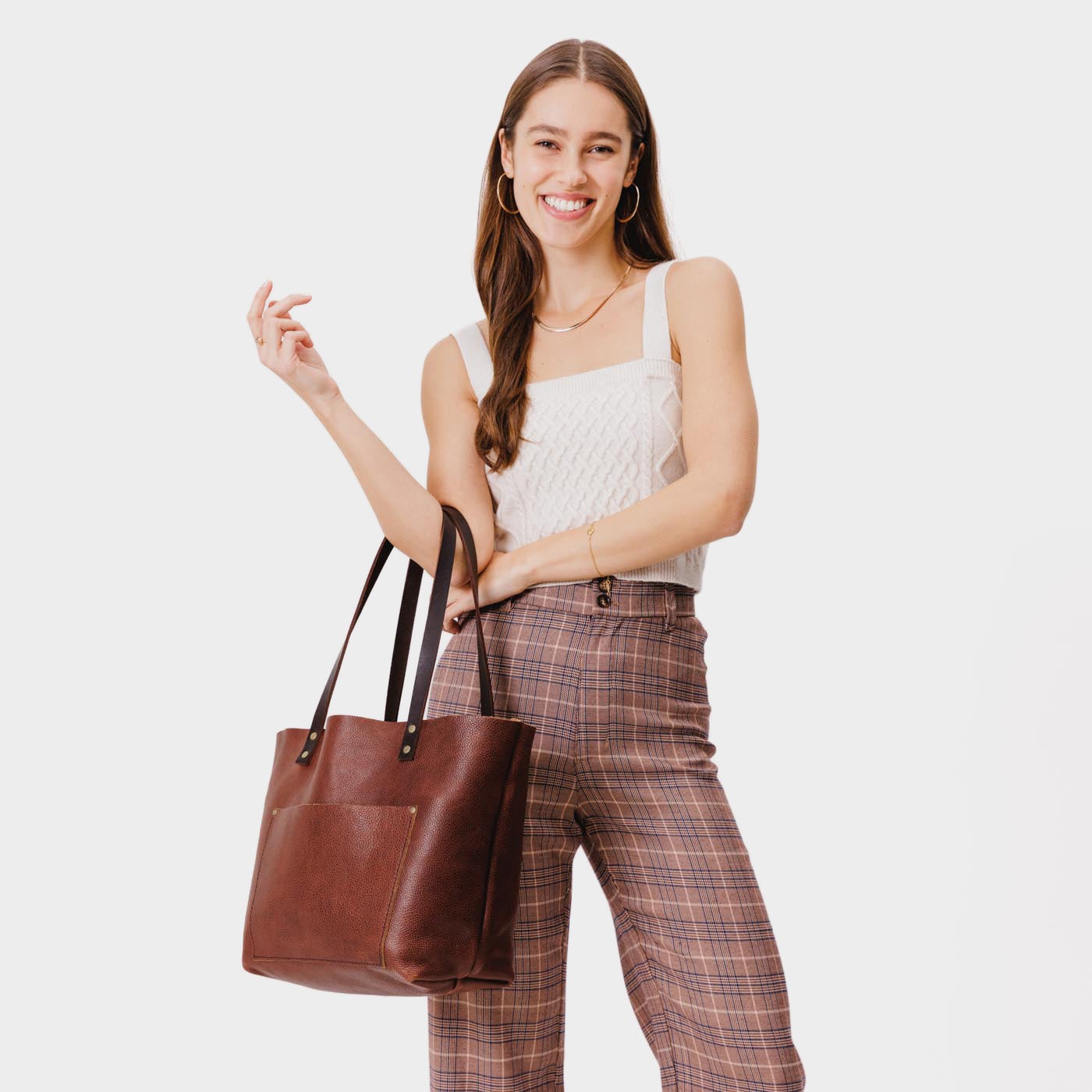 Nutmeg*Classic | Model holding large leather tote bag with sturdy bridle handles and front pocket