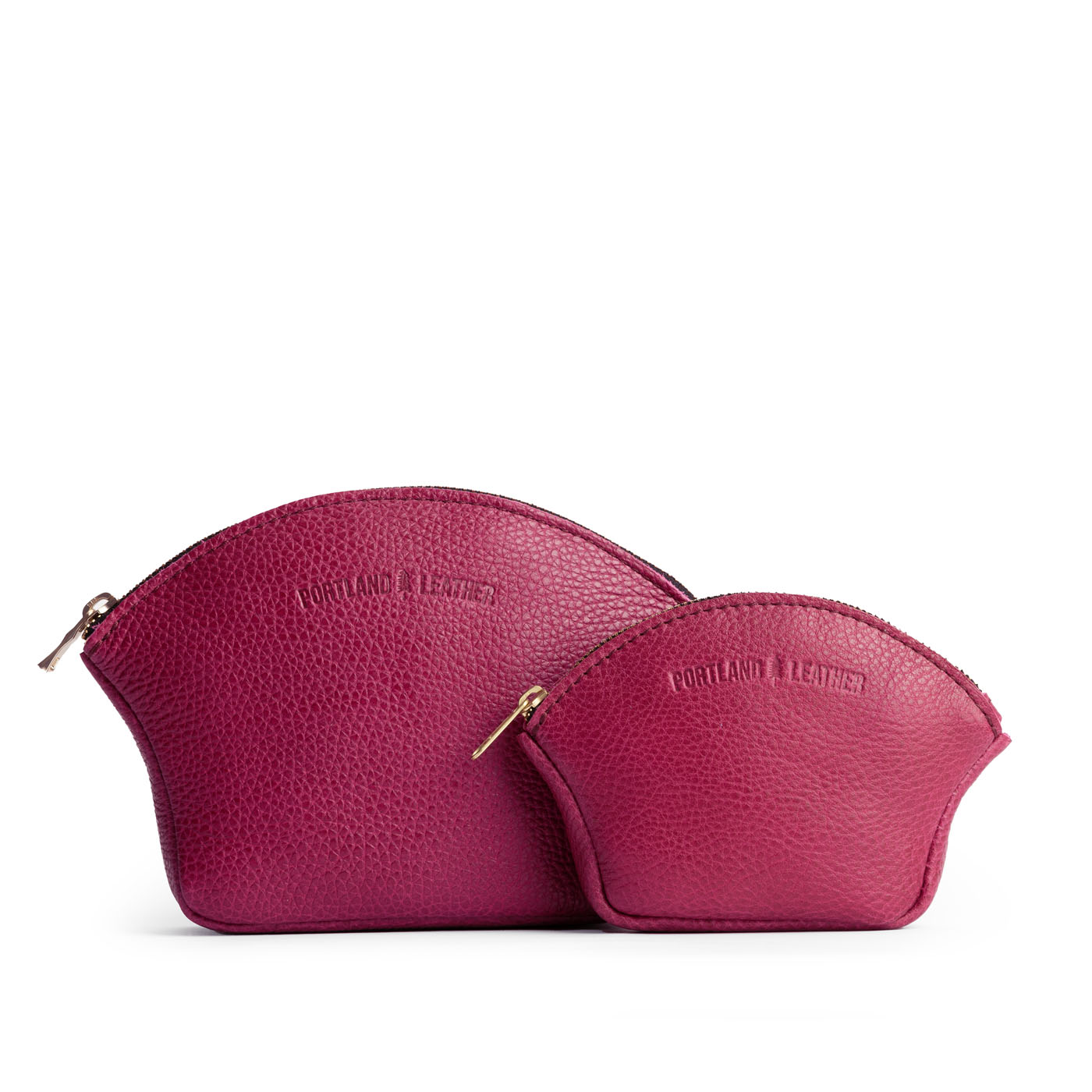 Cosmo | Comparison shot of small and large seashell shaped leather makeup bags with curved top zipper and flat bottom