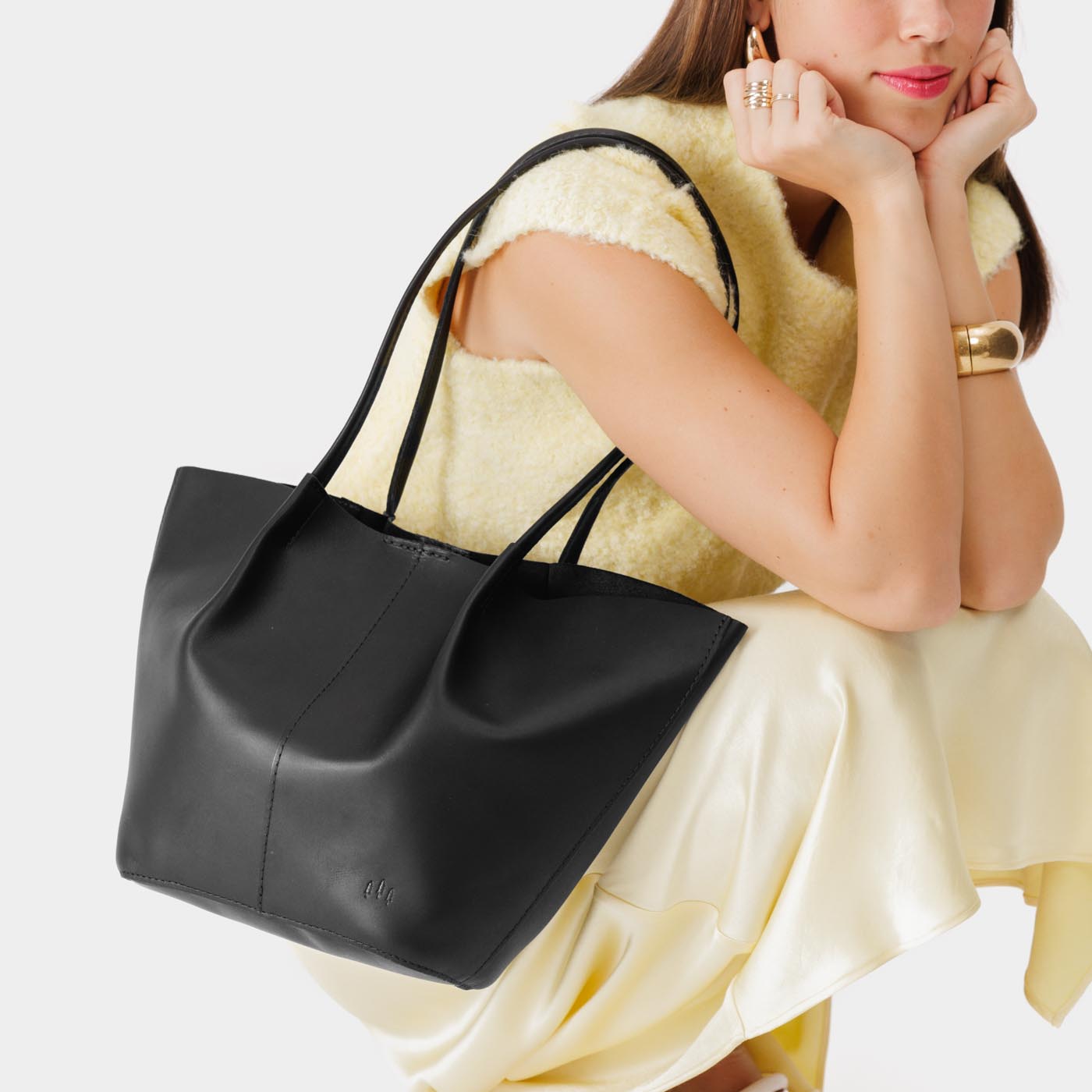 Black Large | Model holding wide bucket shaped tote bag with matching leather handles