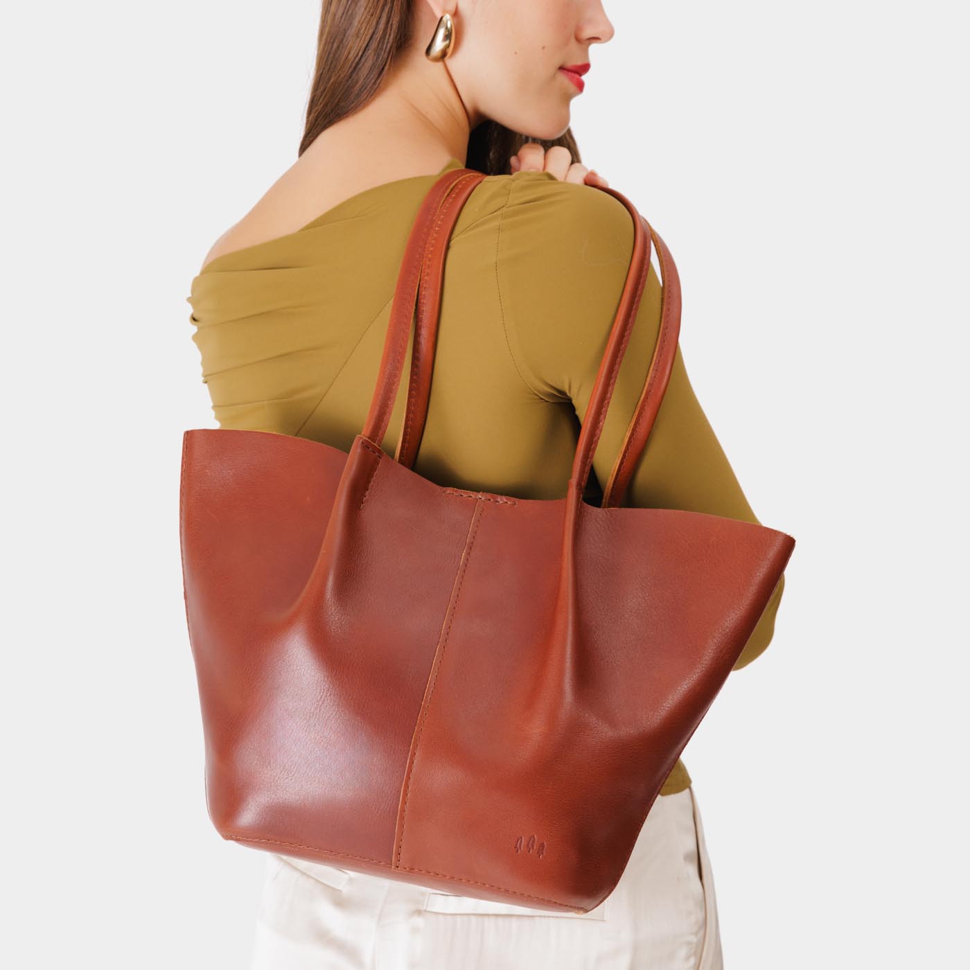 Chestnut Large | Model holding wide bucket shaped tote bag with matching leather handles