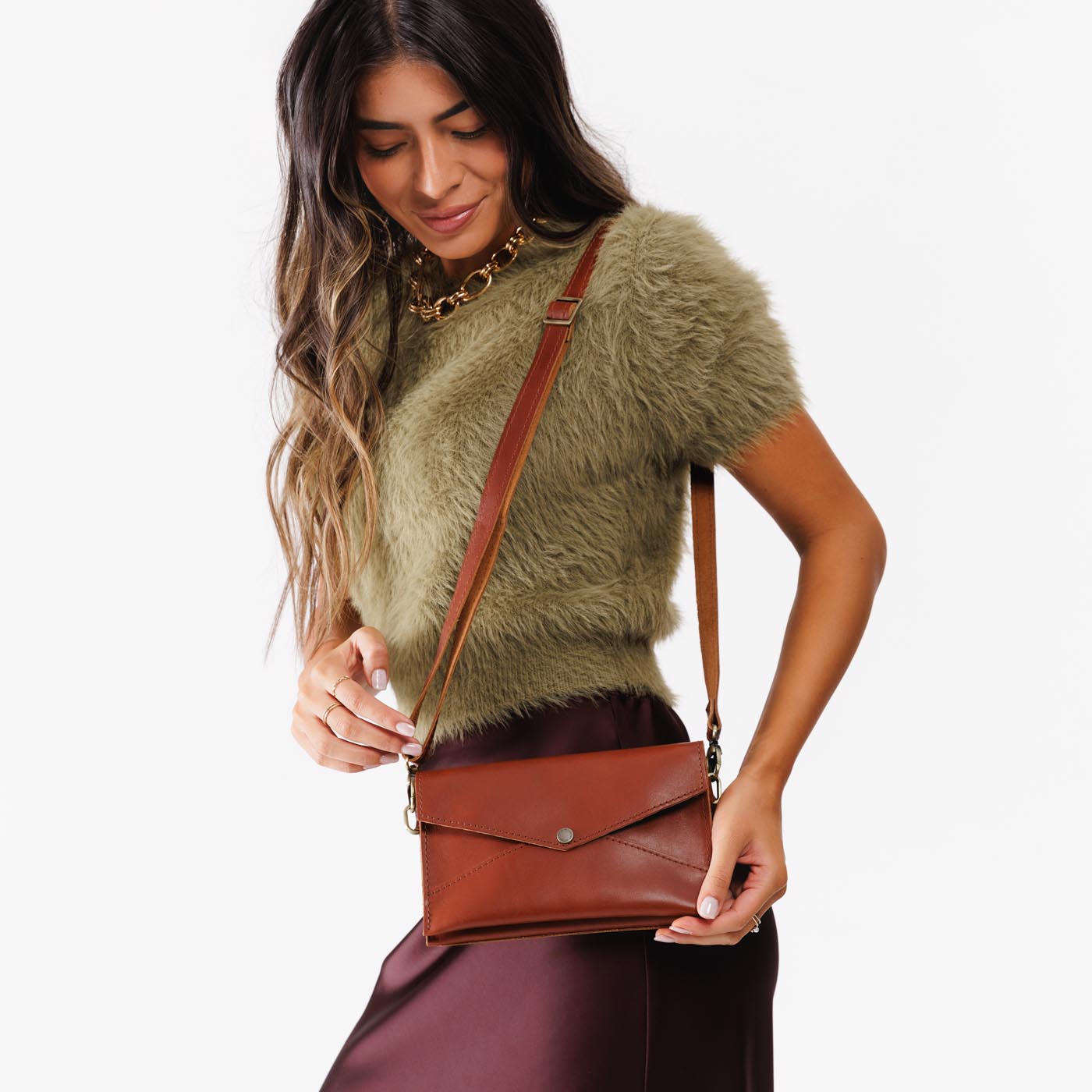 Chestnut | Model wearing envelope shaped clutch wallet with crossbody strap