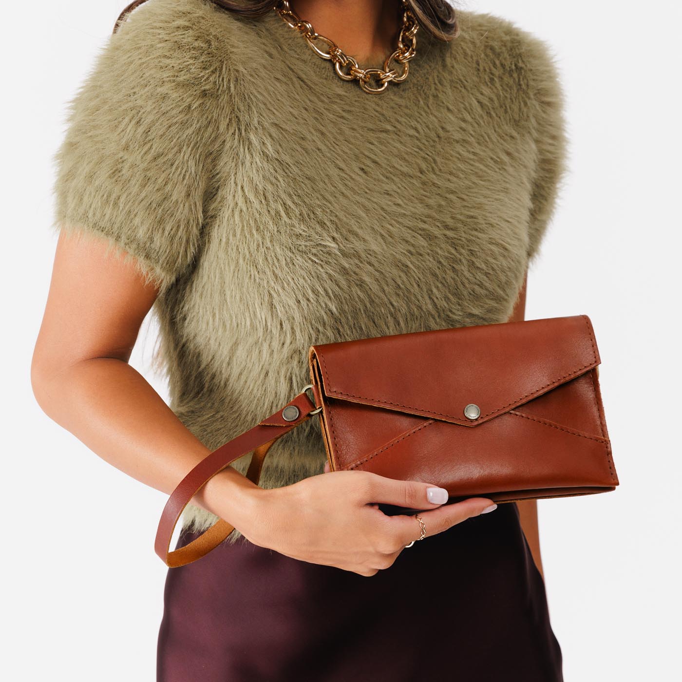 Chestnut | Model wearing envelope shaped clutch wallet with crossbody strap