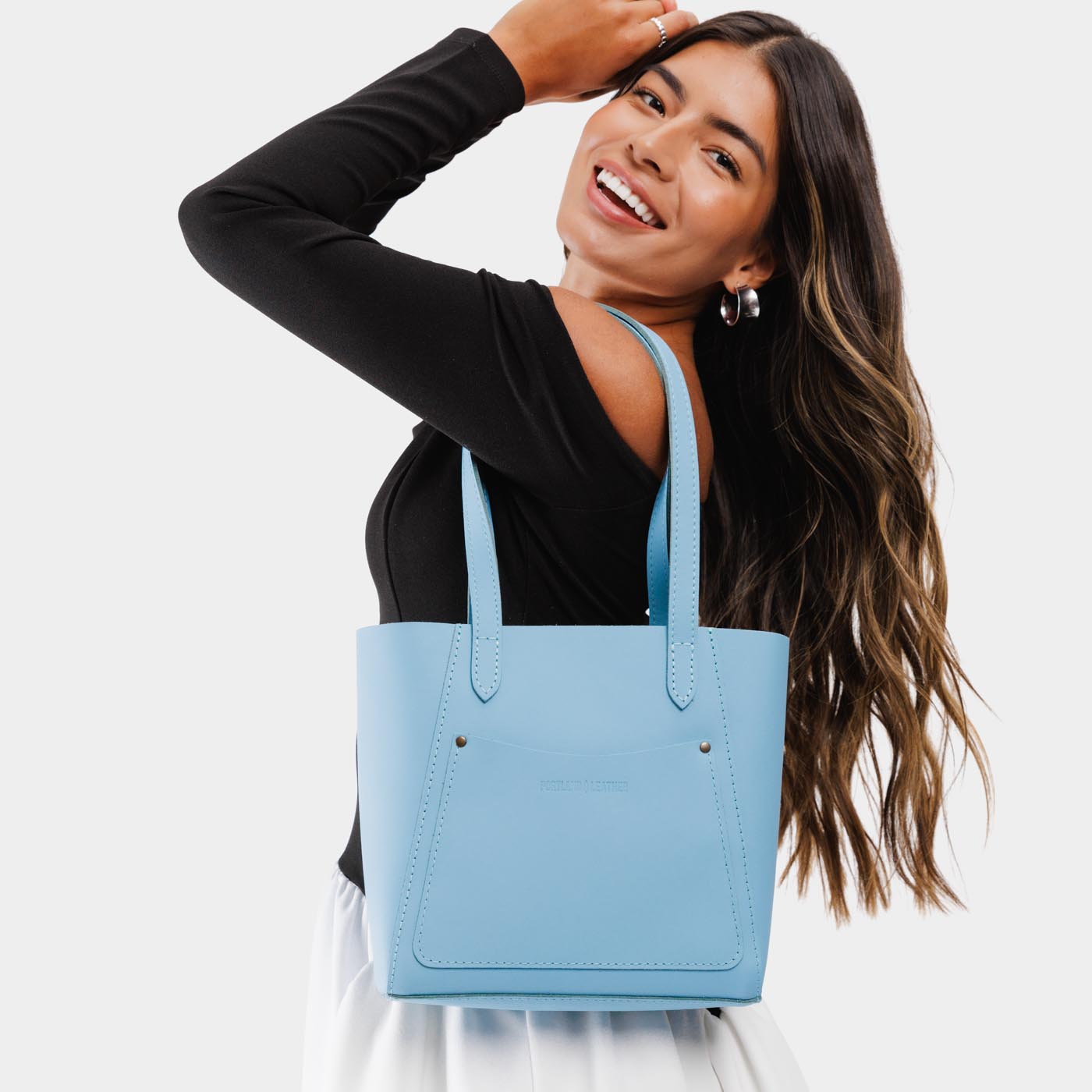 Glacial Blue*Small | Model holding dual shoulder strap tote bag with an exterior pocket