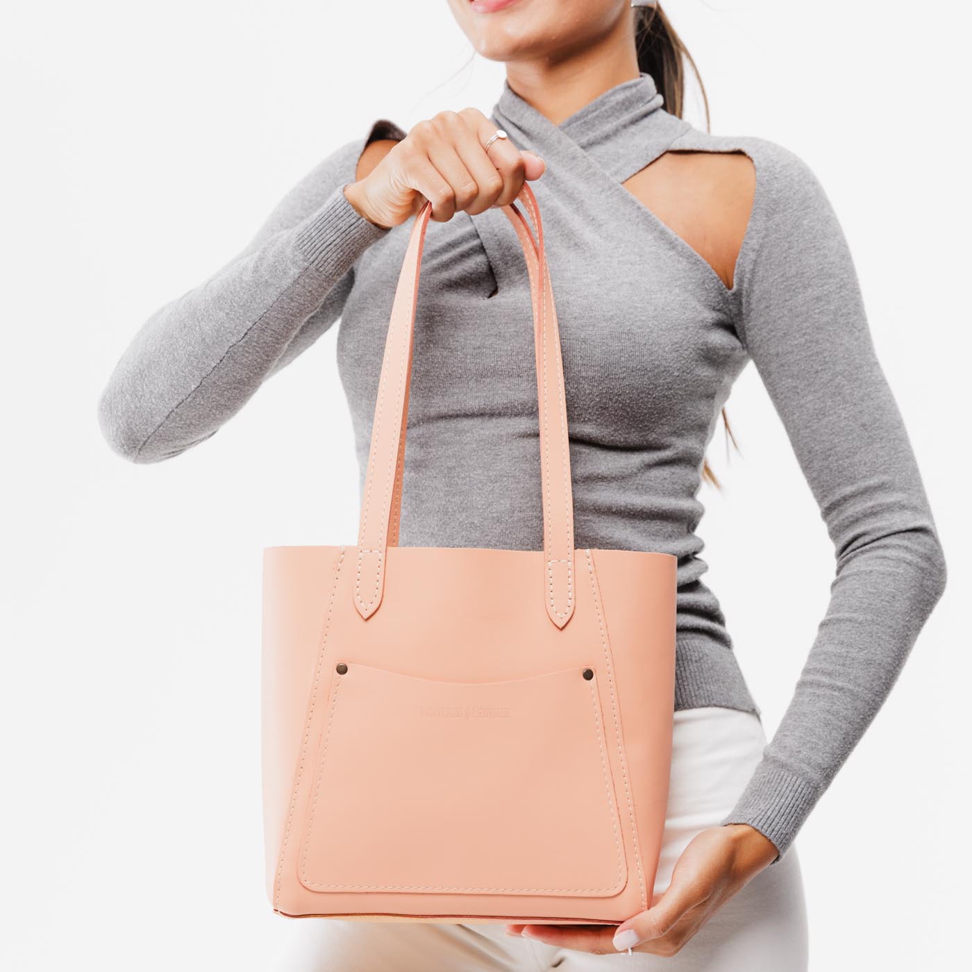 Mamey*Small | Model holding dual shoulder strap tote bag with an exterior pocket