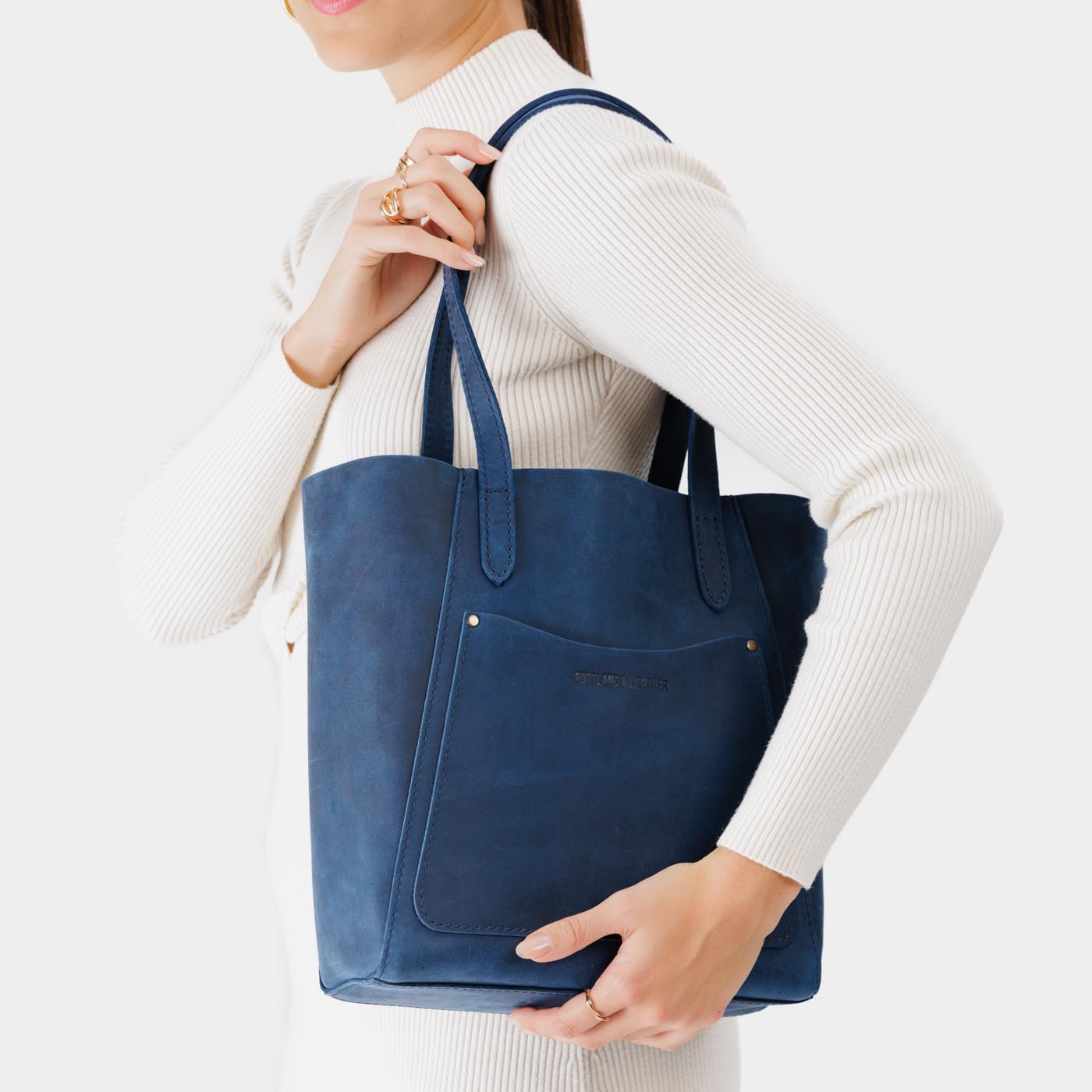 Deep Water Large | Model holding dual shoulder strap tote bag with an exterior pocket