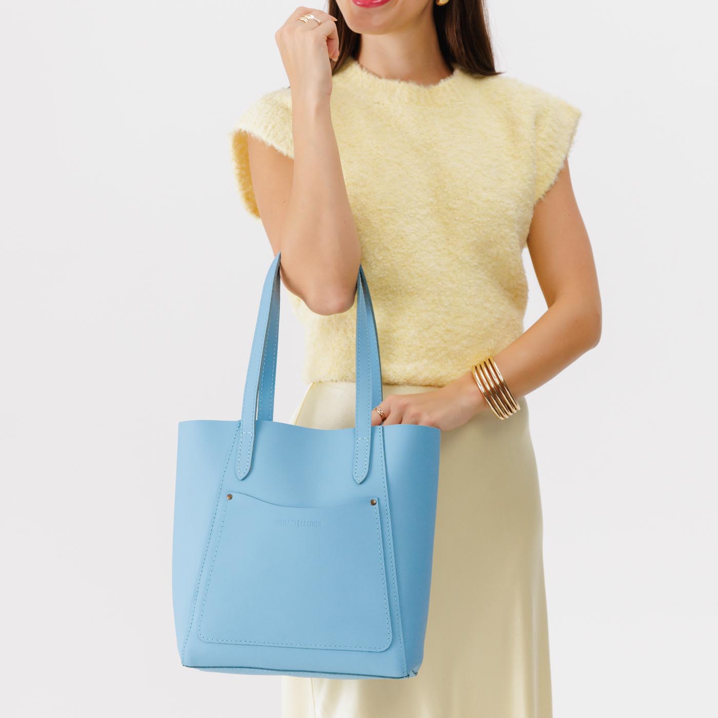 Glacial Blue Large | Model holding dual shoulder strap tote bag with an exterior pocket