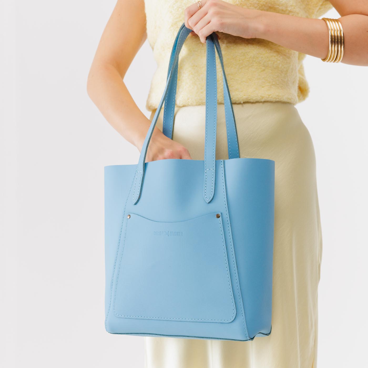 Glacial Blue*Large | Model holding dual shoulder strap tote bag with an exterior pocket