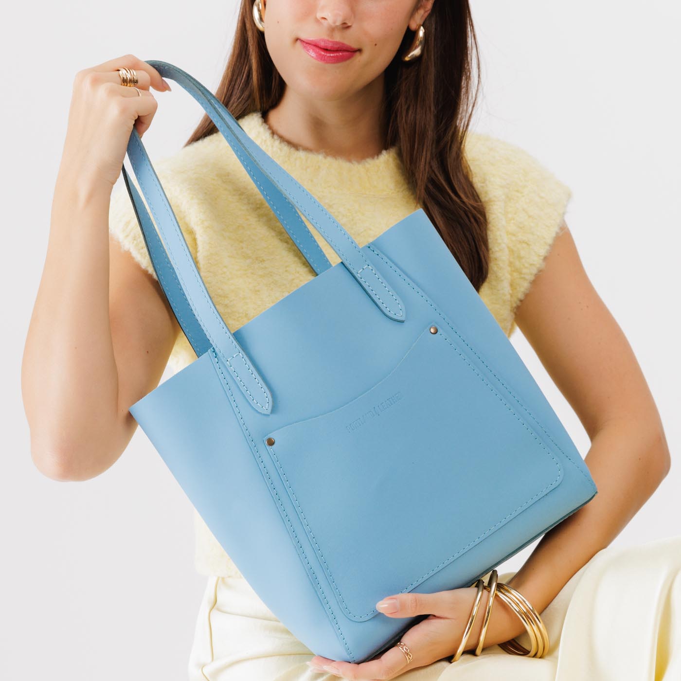 Glacial Blue Large | Model holding dual shoulder strap tote bag with an exterior pocket