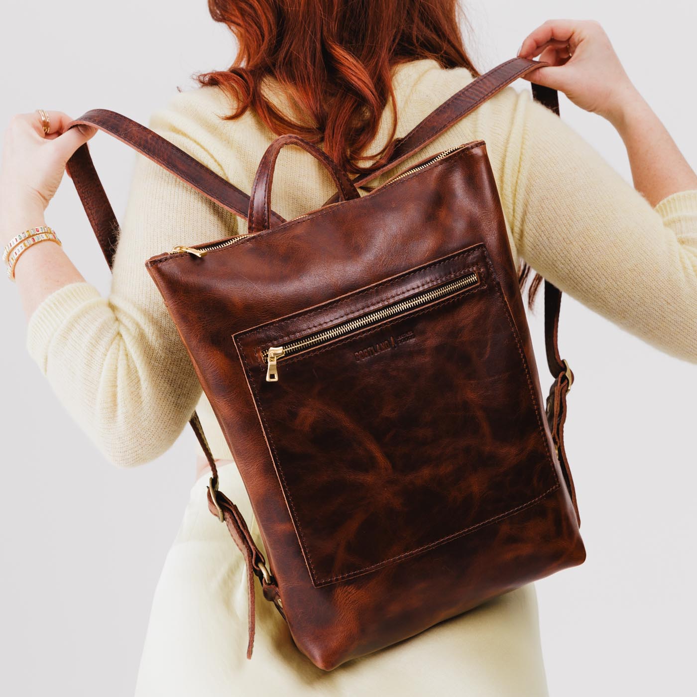 All Color: Lava | Model wearing rectangular slim leather laptop backpack