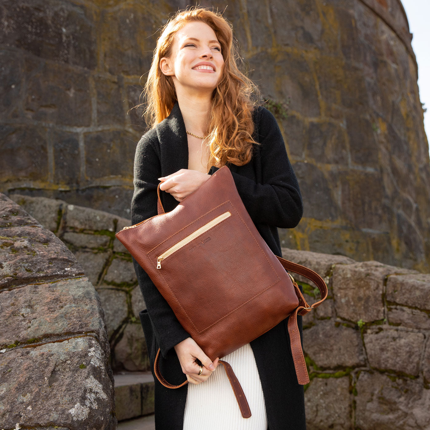 Nutmeg | Model holding rectangular slim leather laptop backpack