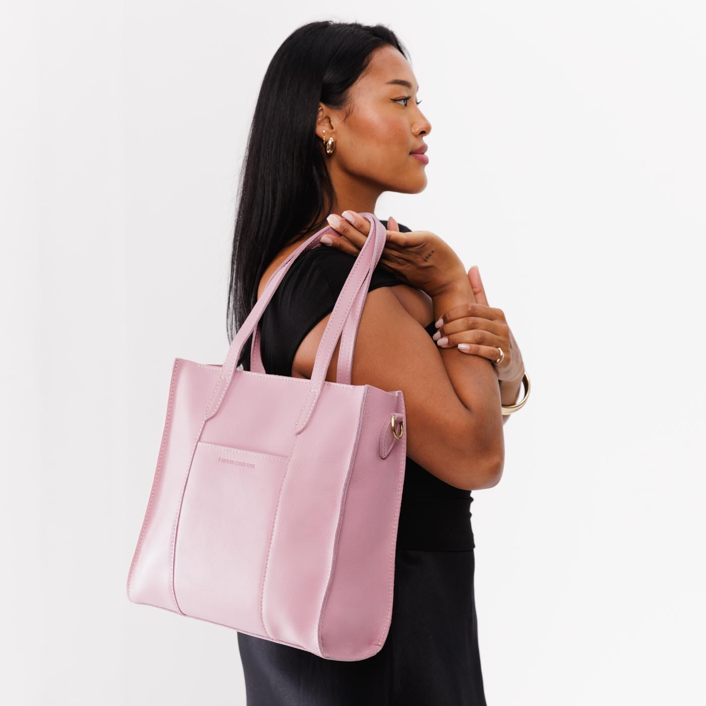 Vintage Pink North/South | Model holding structured large tote bag with overlapping panels and crossbody strap