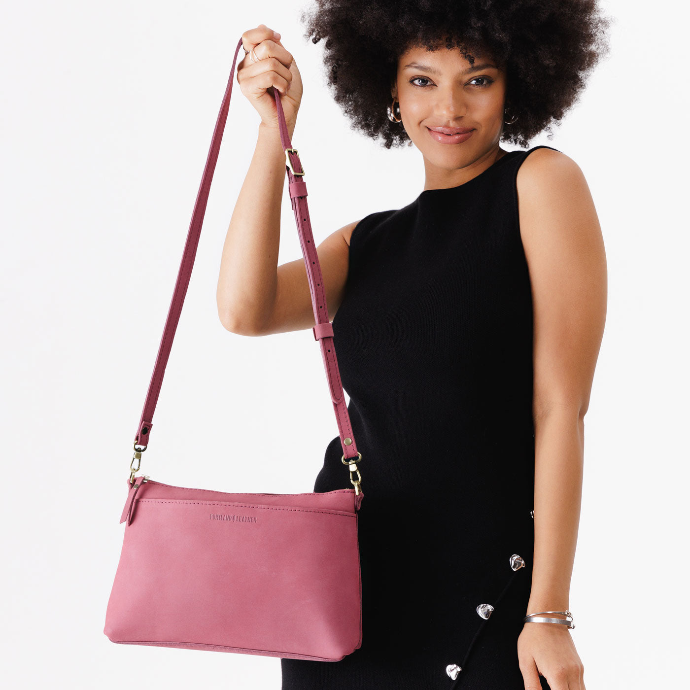 Foxglove | Model holding midsize zip top crossbody bag with detachable strap