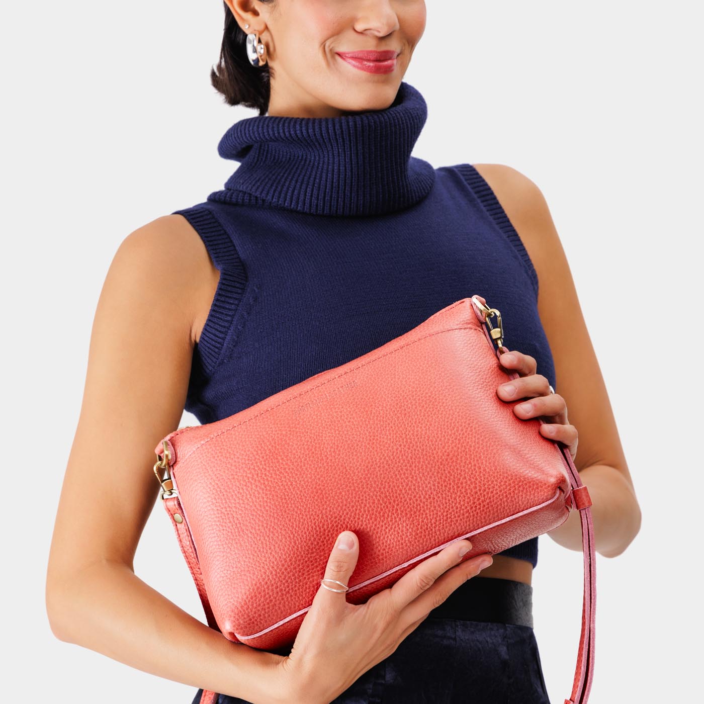 Watermelon | Model holding midsize zip top crossbody bag with detachable strap