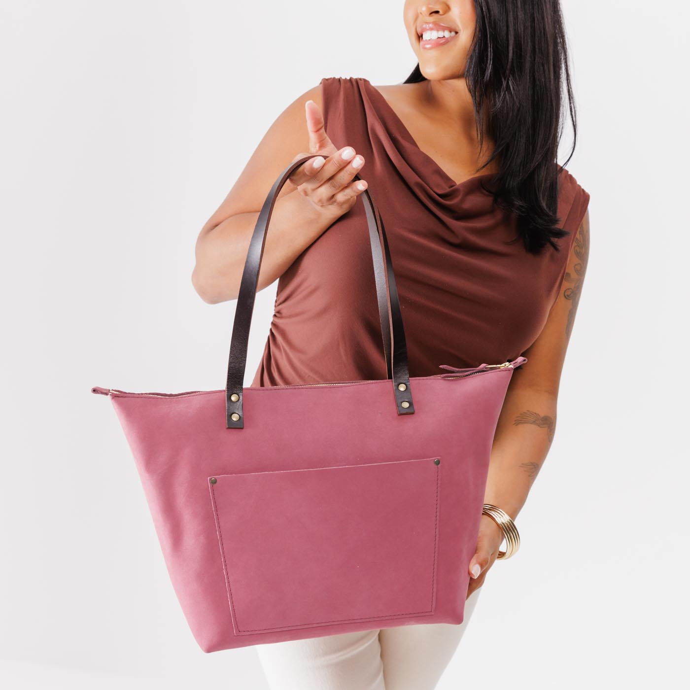 Foxglove*Zipper | Model holding large leather tote bag with sturdy bridle handles and front pocket