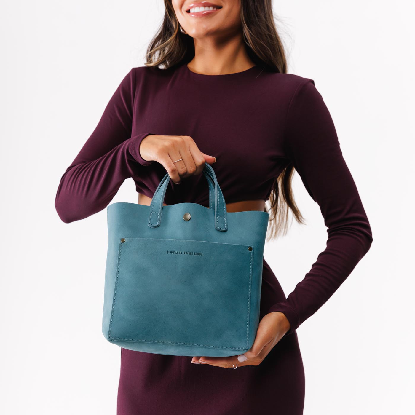 Aqua Classic | Model holding crossbody tote bag with zipper closure and front pocket