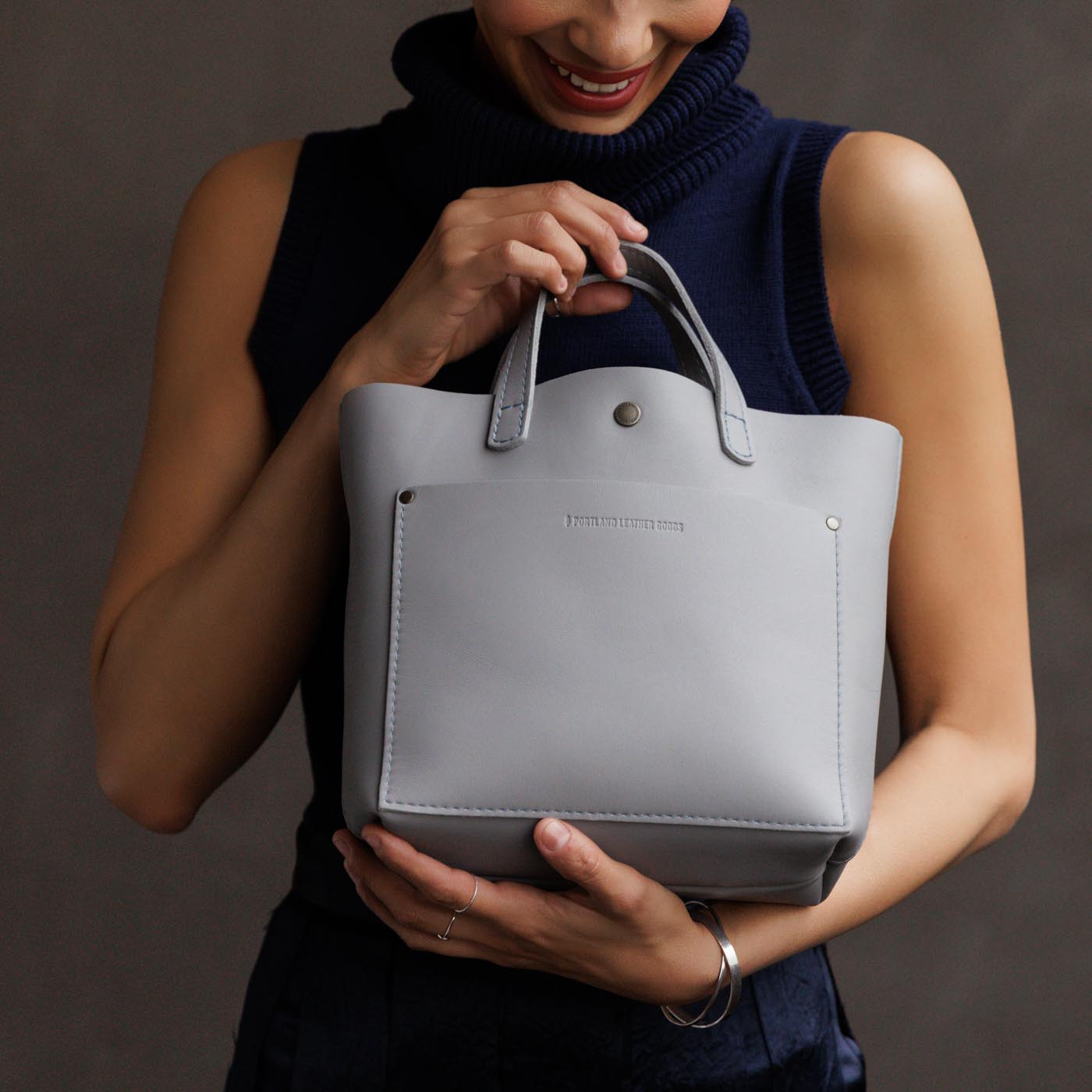 Formal Grey*Classic | Model holding crossbody tote bag with snap closure and front pocket