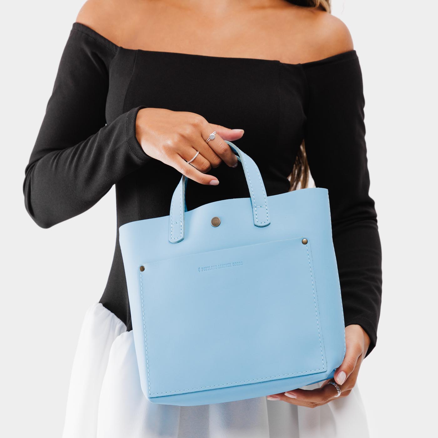 Glacial Blue*Classic | Model holding crossbody tote bag with snap closure and front pocket