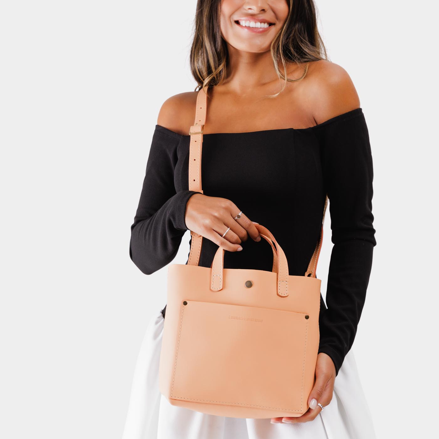 Mamey Classic | Model holding crossbody tote bag with snap closure and front pocket