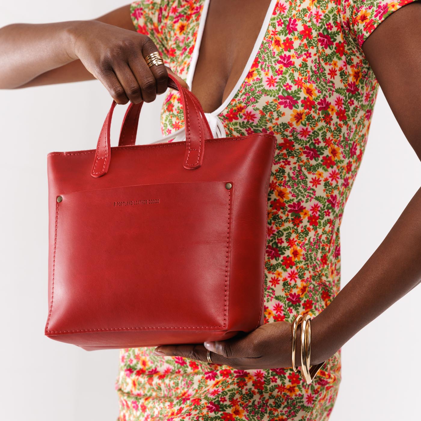 Ruby Zipper | Model holding crossbody tote bag with zipper closure and front pocket