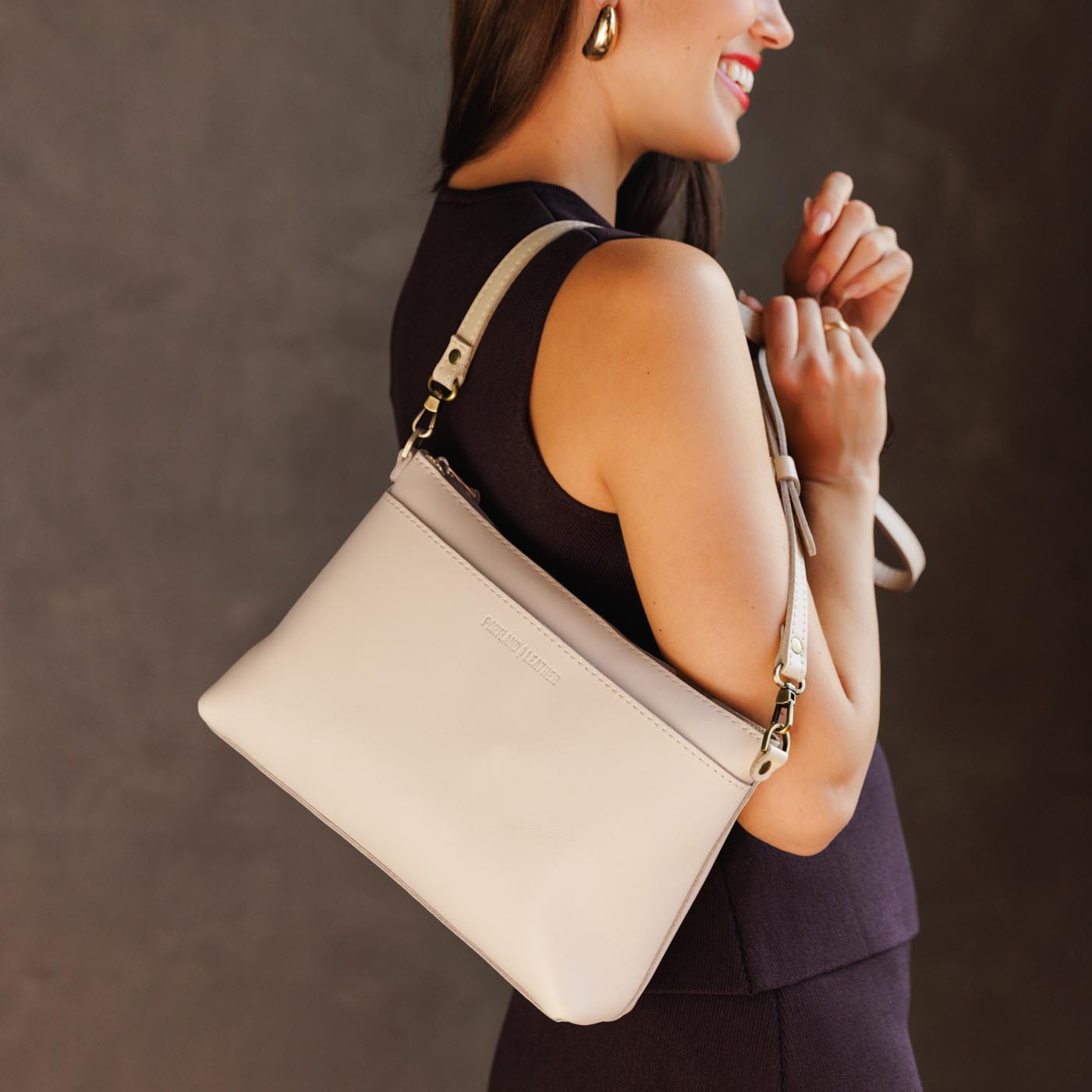 Bone | Model holding midsize zip top crossbody bag with detachable strap