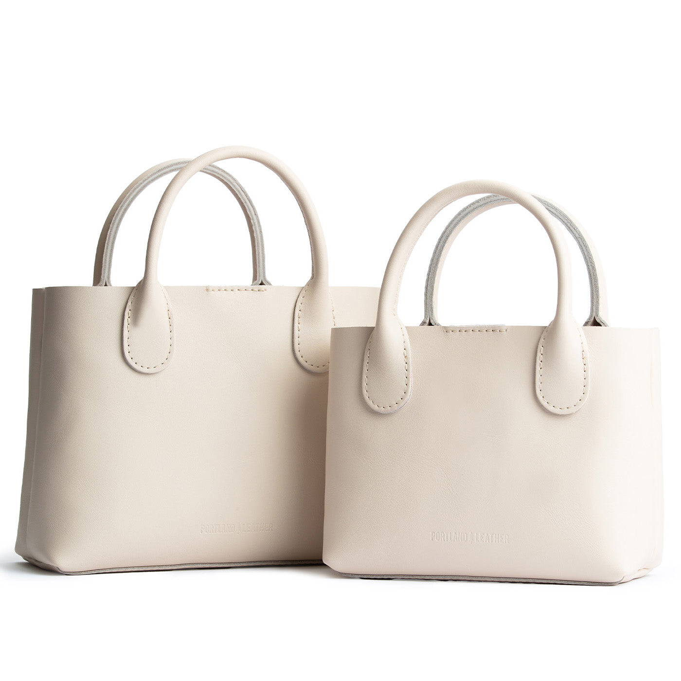 Bone | Side by side of both tote purses with structured leather handles and crossbody strap