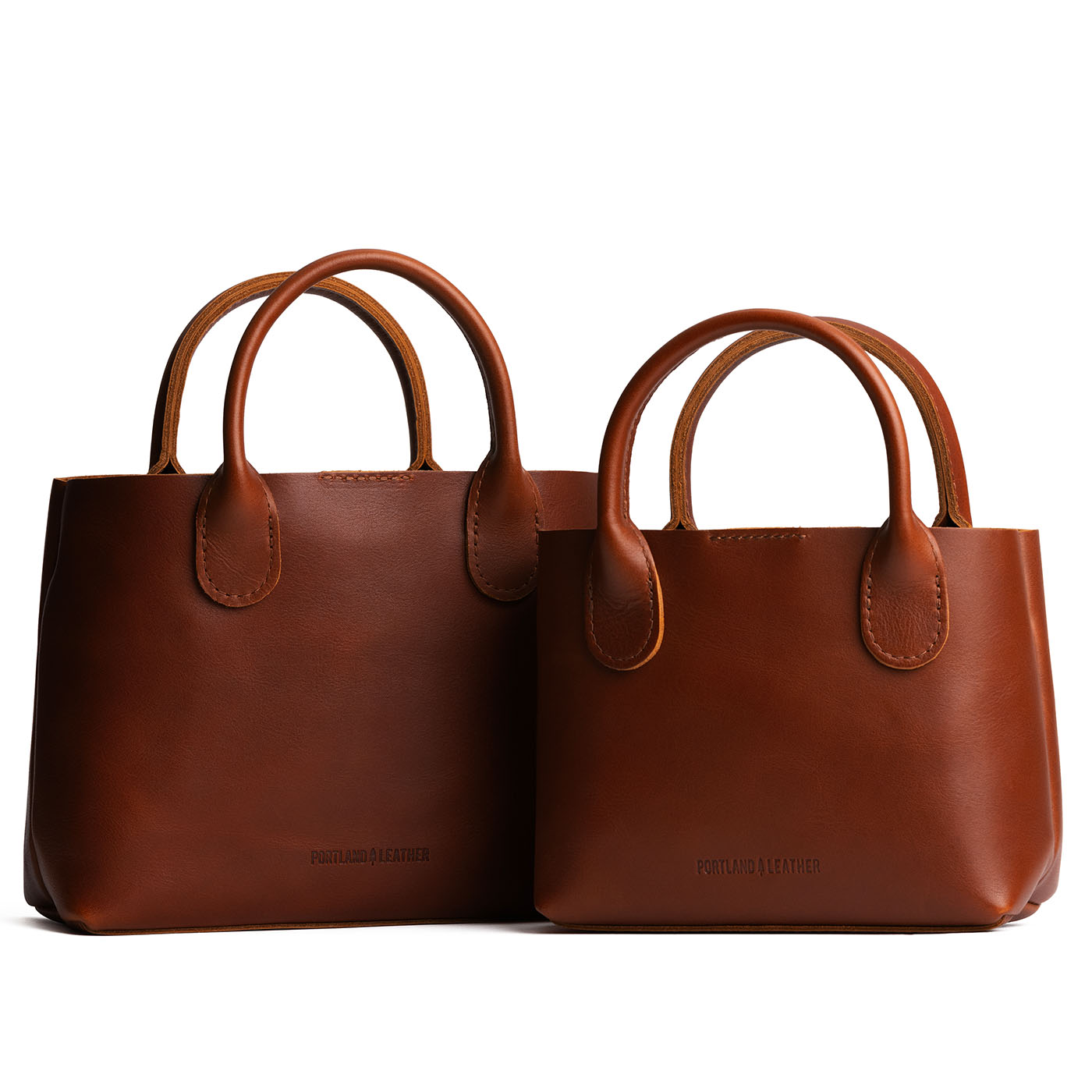 Chestnut | Side by side of both tote purses with structured leather handles and crossbody strap