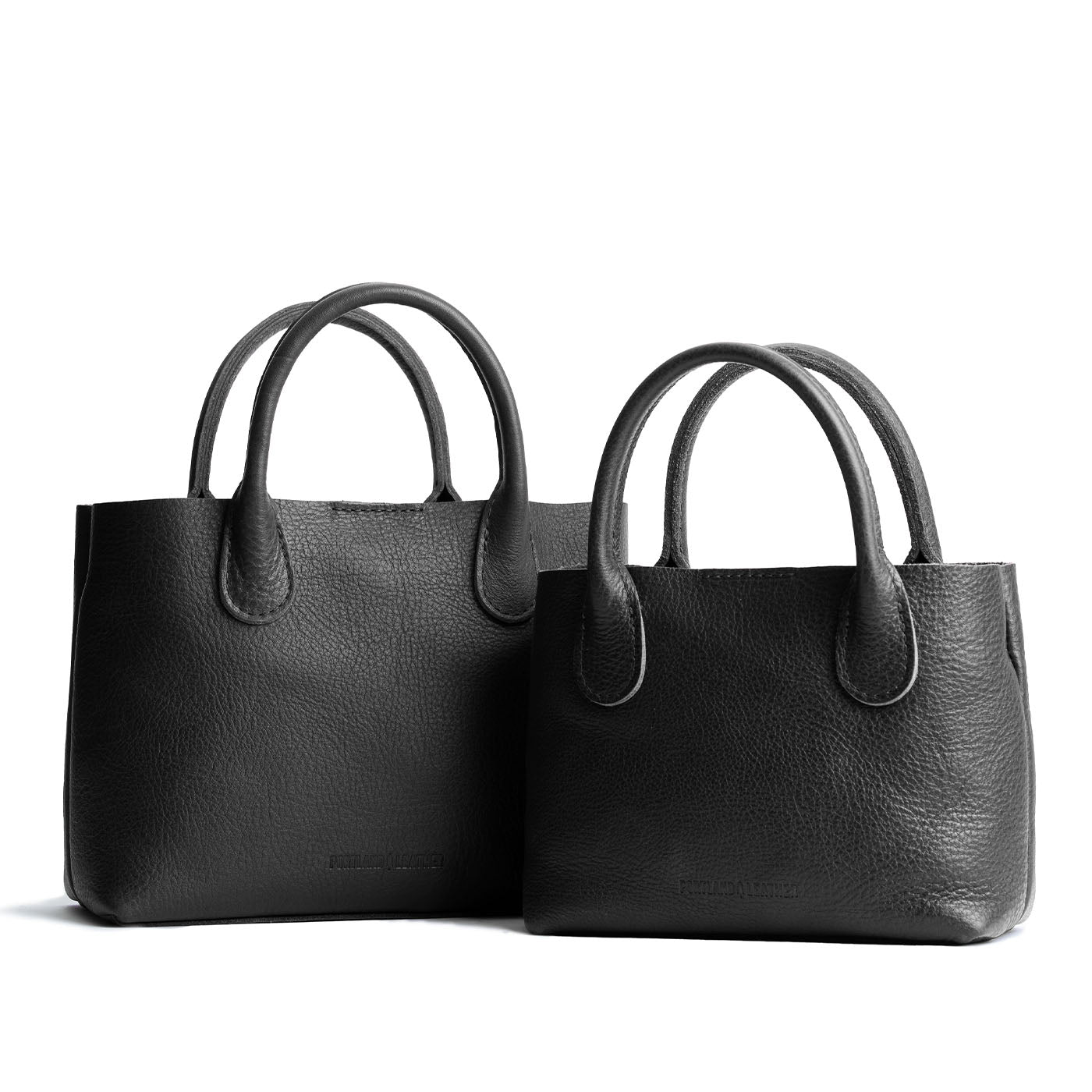 Pebbled--black | Side by side of both tote purses with structured leather handles and crossbody strap