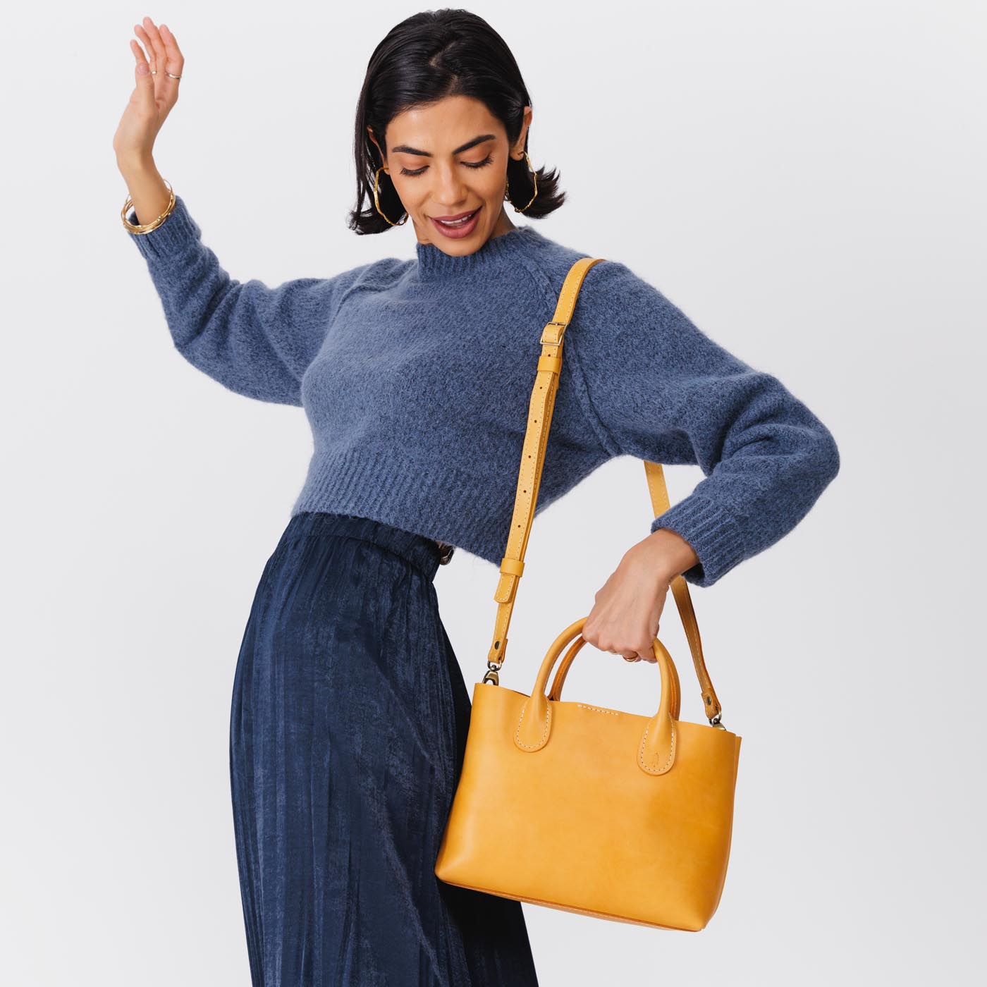 Sunflower Large | Model holding mid-size tote purse with  structured leather handles and crossbody strap