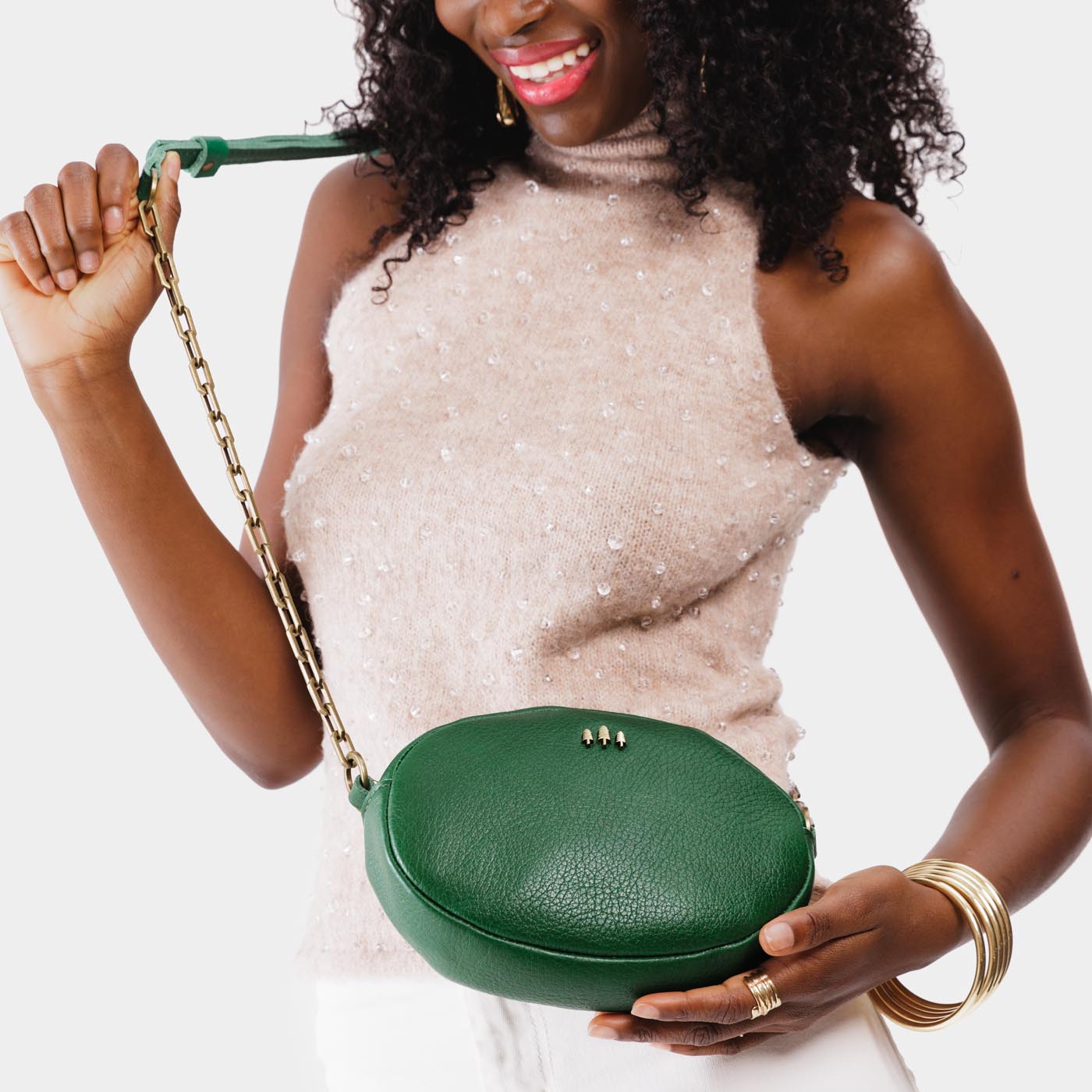 Bacalar | Model wearing oval leather purse with metal crossbody chain strap and adjustable leather shoulder guard