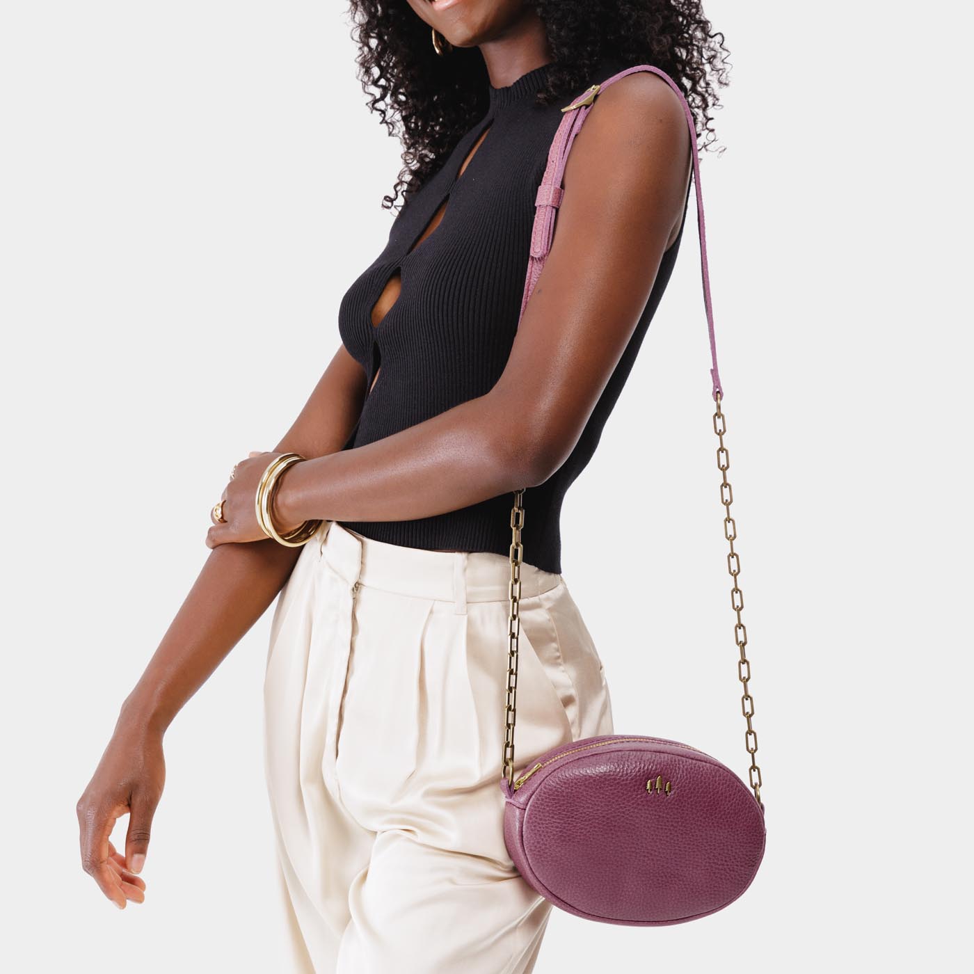 Kyoto | Model wearing oval leather purse with metal crossbody chain strap and adjustable leather shoulder guard