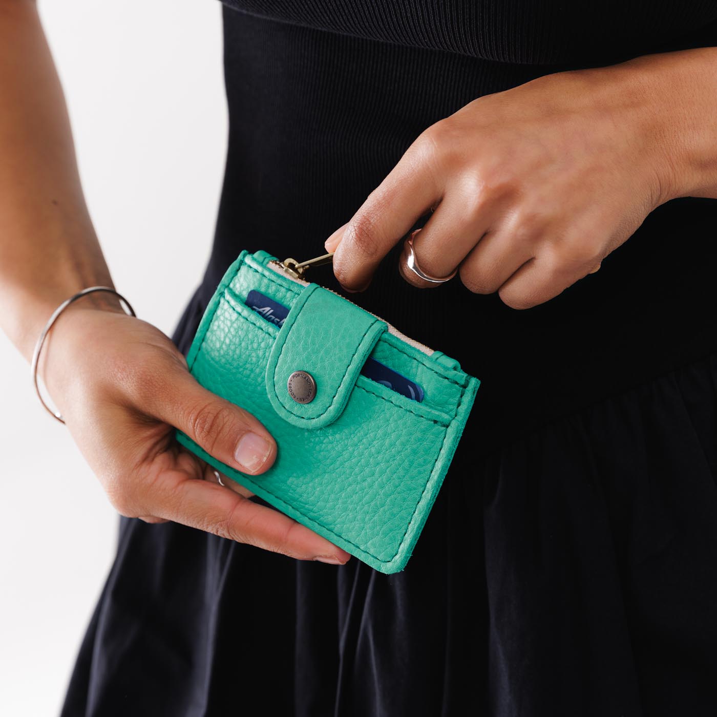 West Palm | Model holding compact wallet with snap closure and zippered pouch