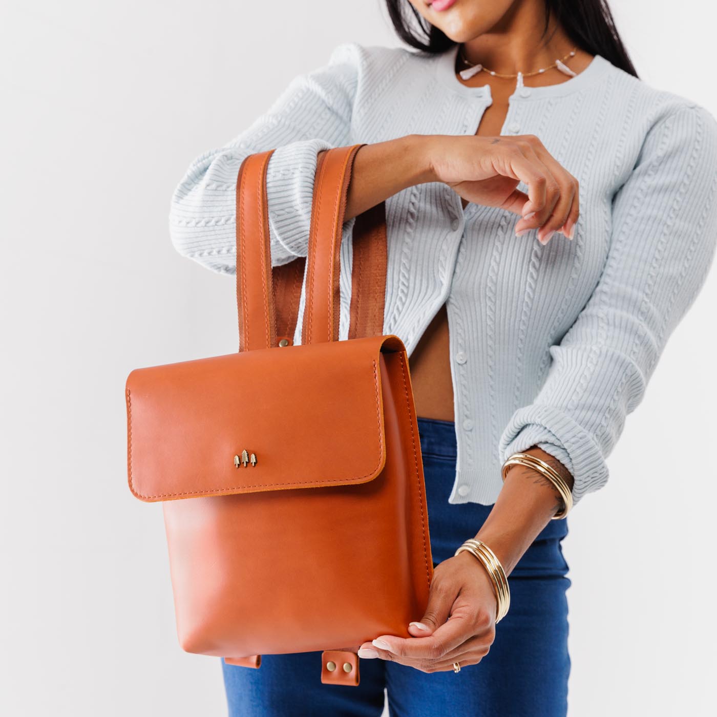 Tuscany | Model holding rectangular backpack with leather lined nylon straps and magnetic flap closure