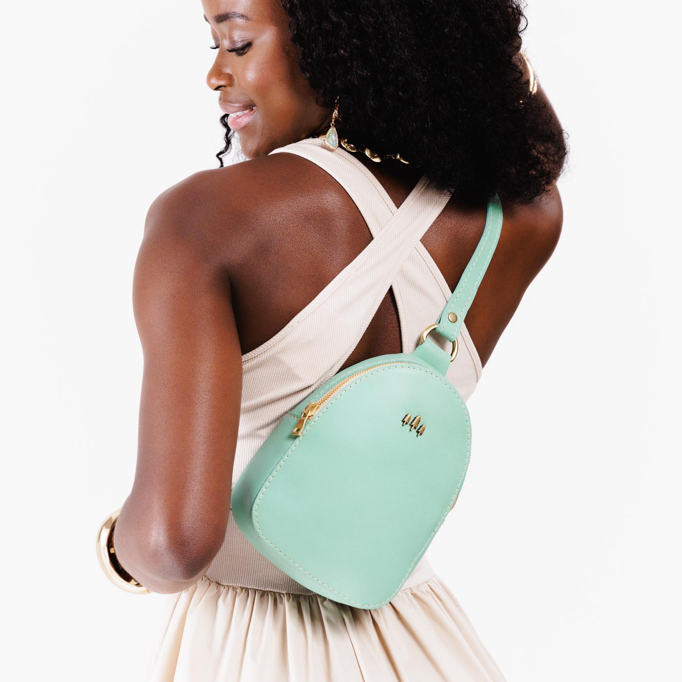 Mint | Model wearing small sling bag with zipper closure and adjustable strap on her back