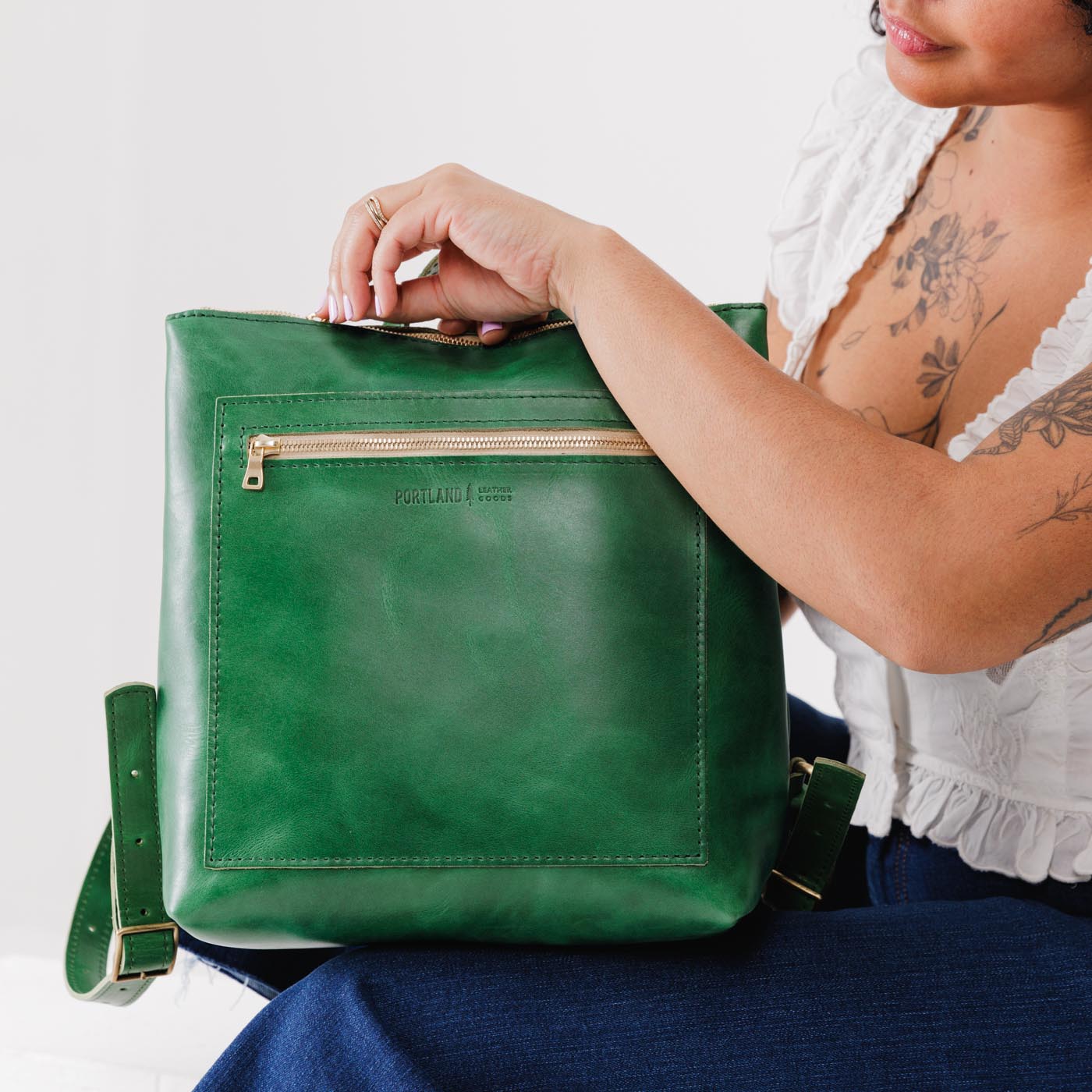 All Color: Cowboy Mint | Model holding square slim leather tote backpack