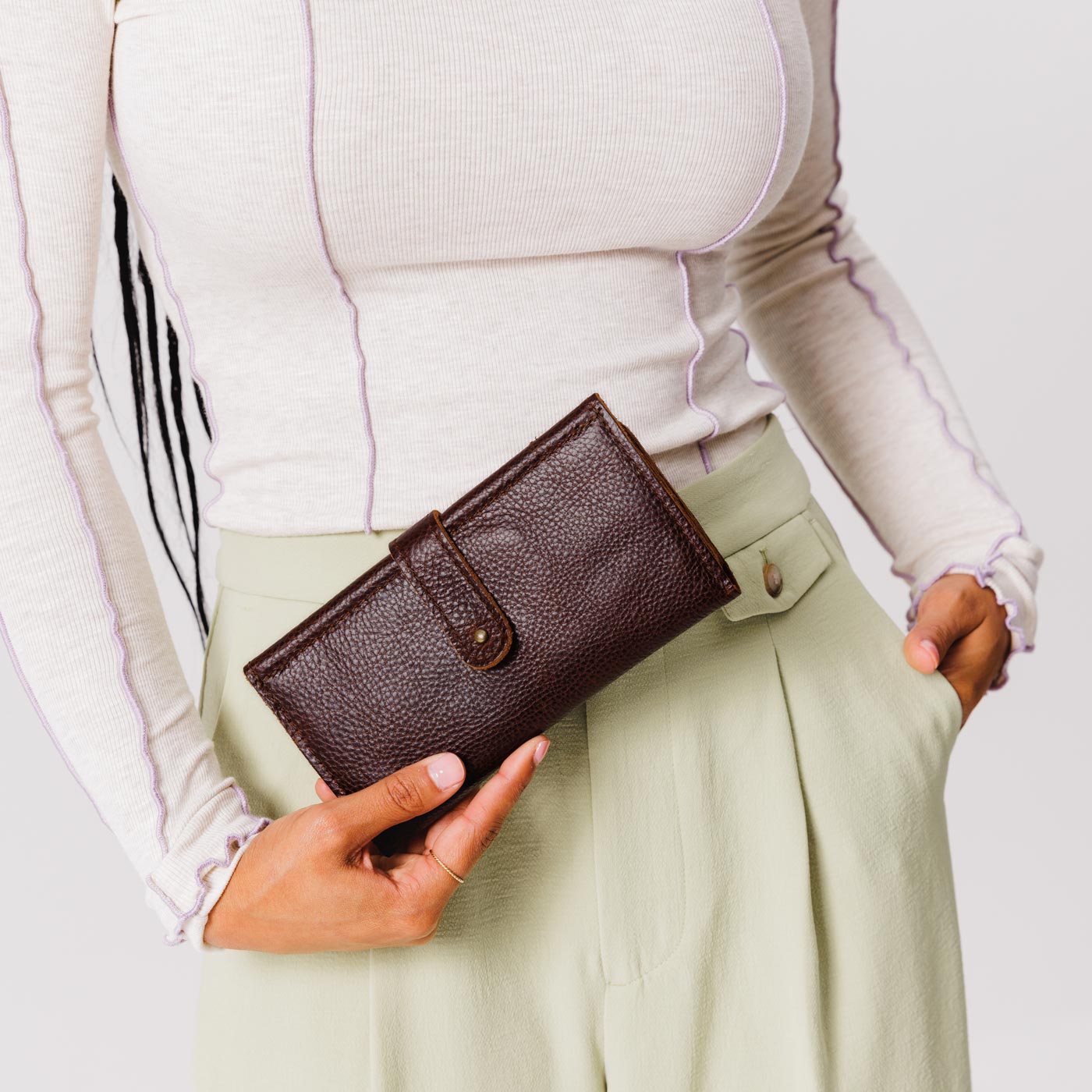 Coldbrew | Model holding leather wallet with Sam Browne closure