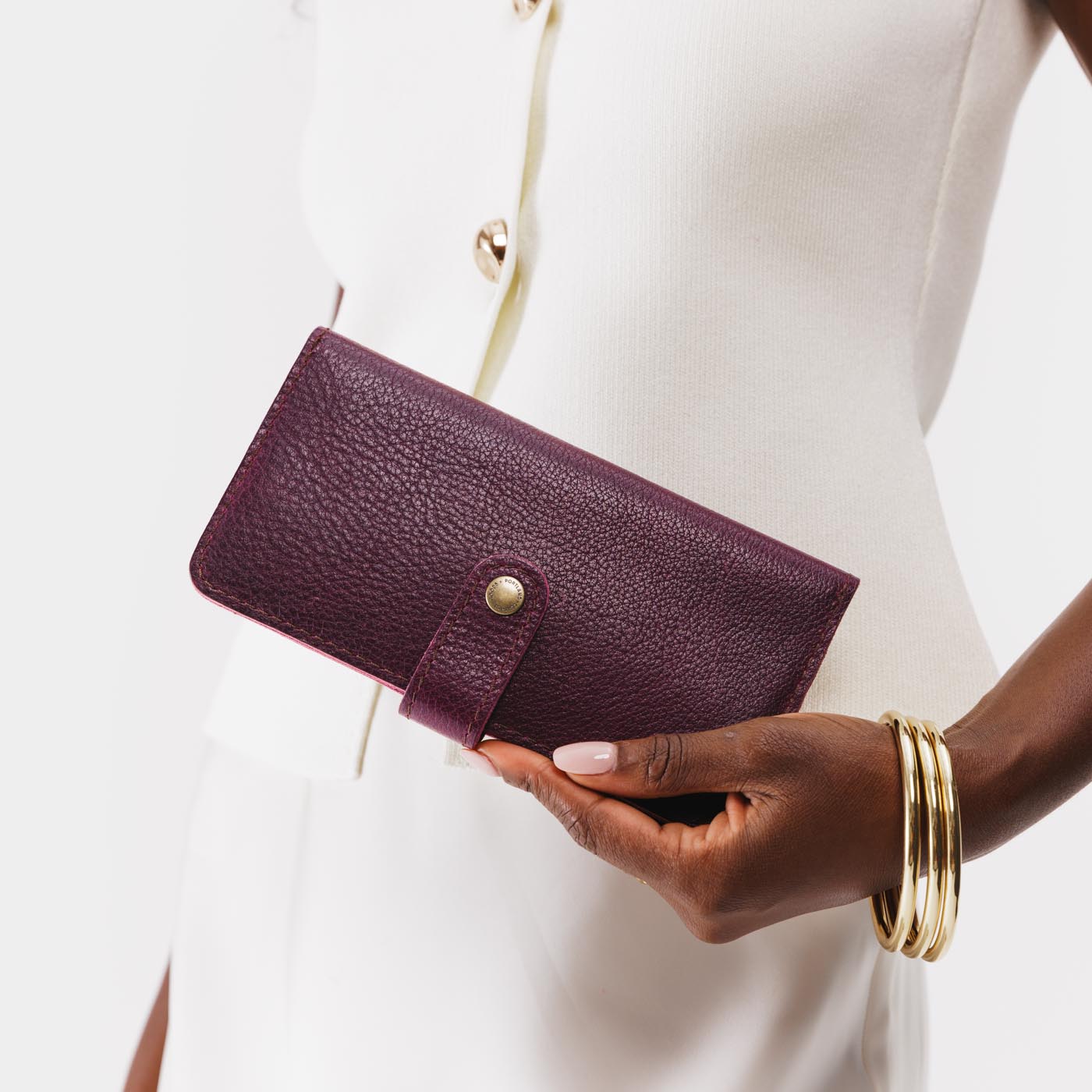 Plum | Model holding leather wallet with snap closed