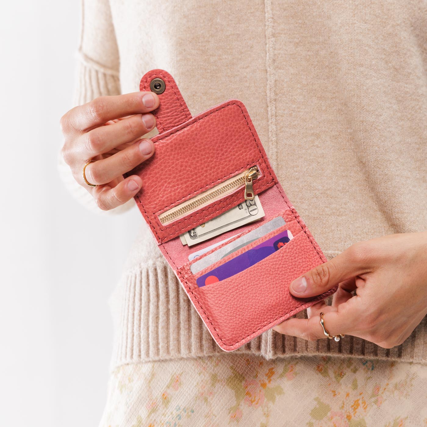 Watermelon | Model holding small leather bifold wallet with snap open