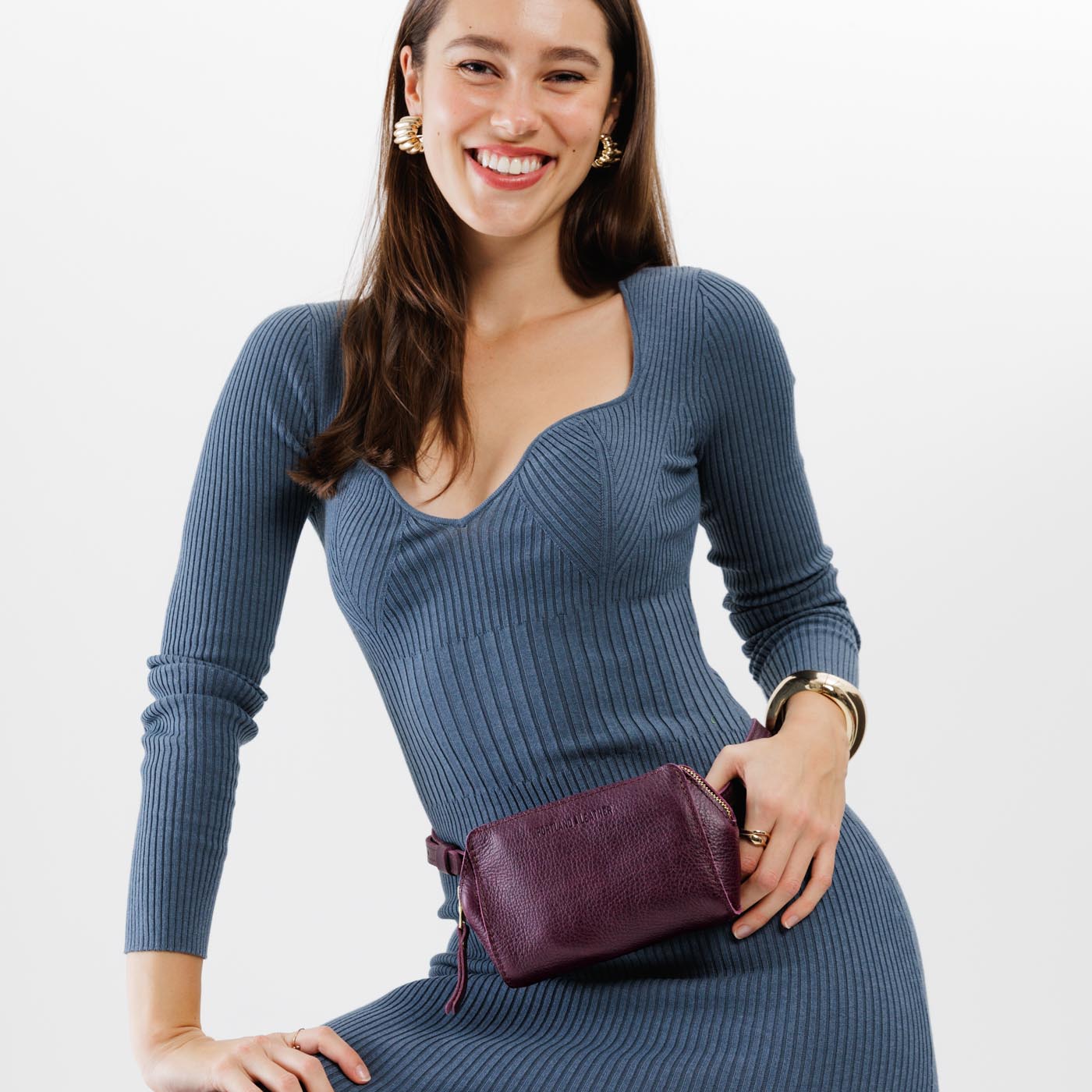  Plum | Model wearing petite bag with top zipper closure and adjustable belt strap on the waist