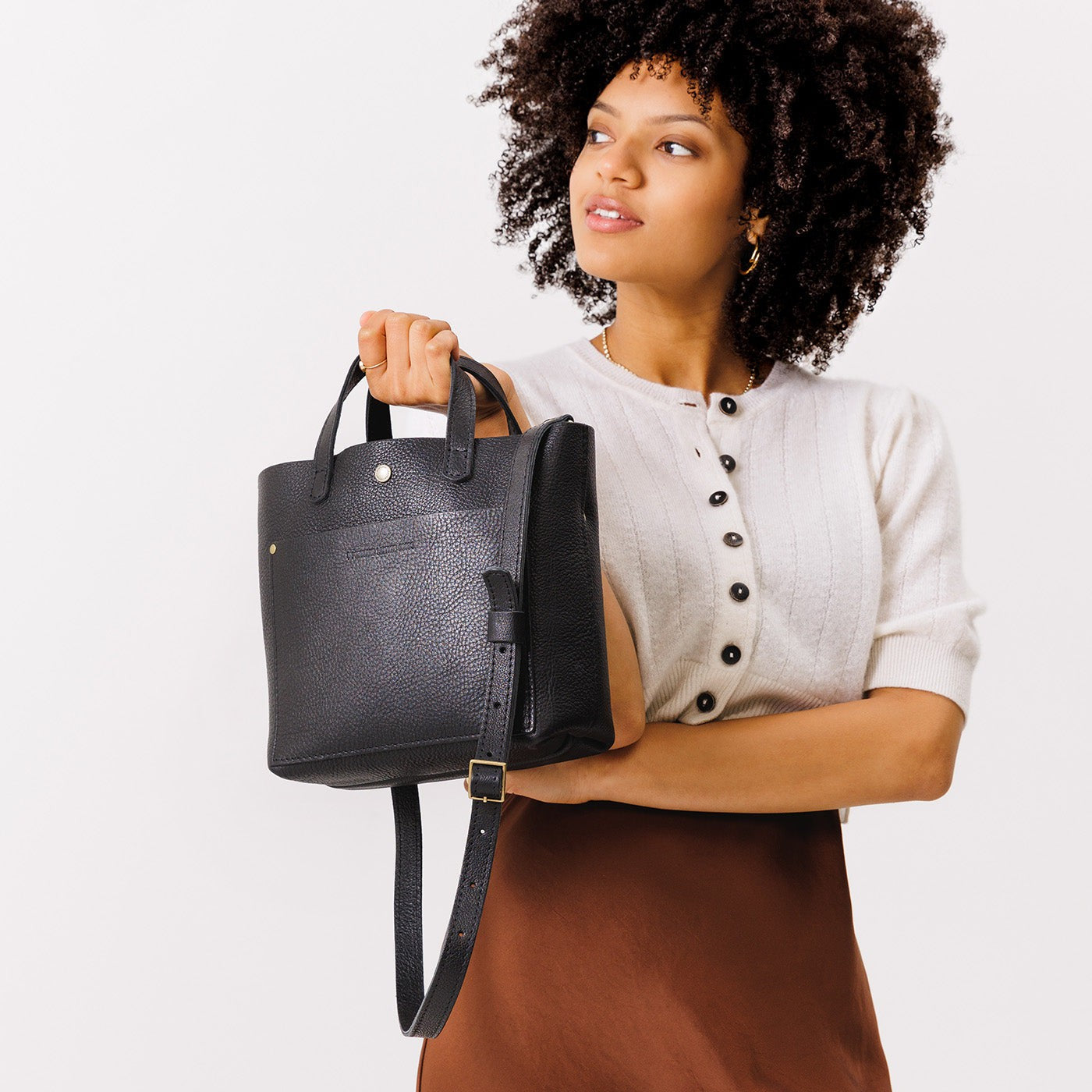 Pebbled--black Classic | Model holding crossbody tote bag with snap closure and front pocket