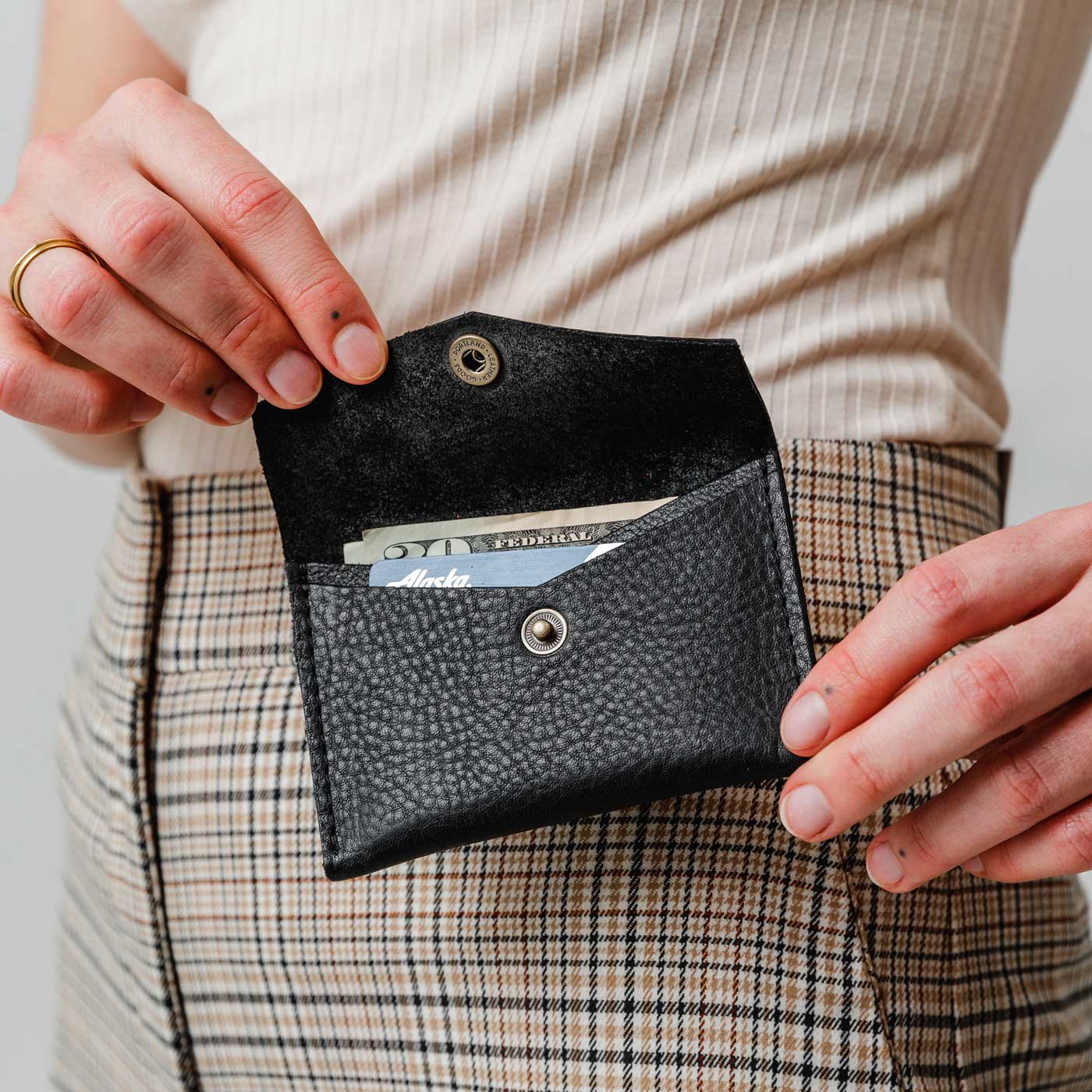 Pebbled--black | Model holding small leather envelope card wallet open