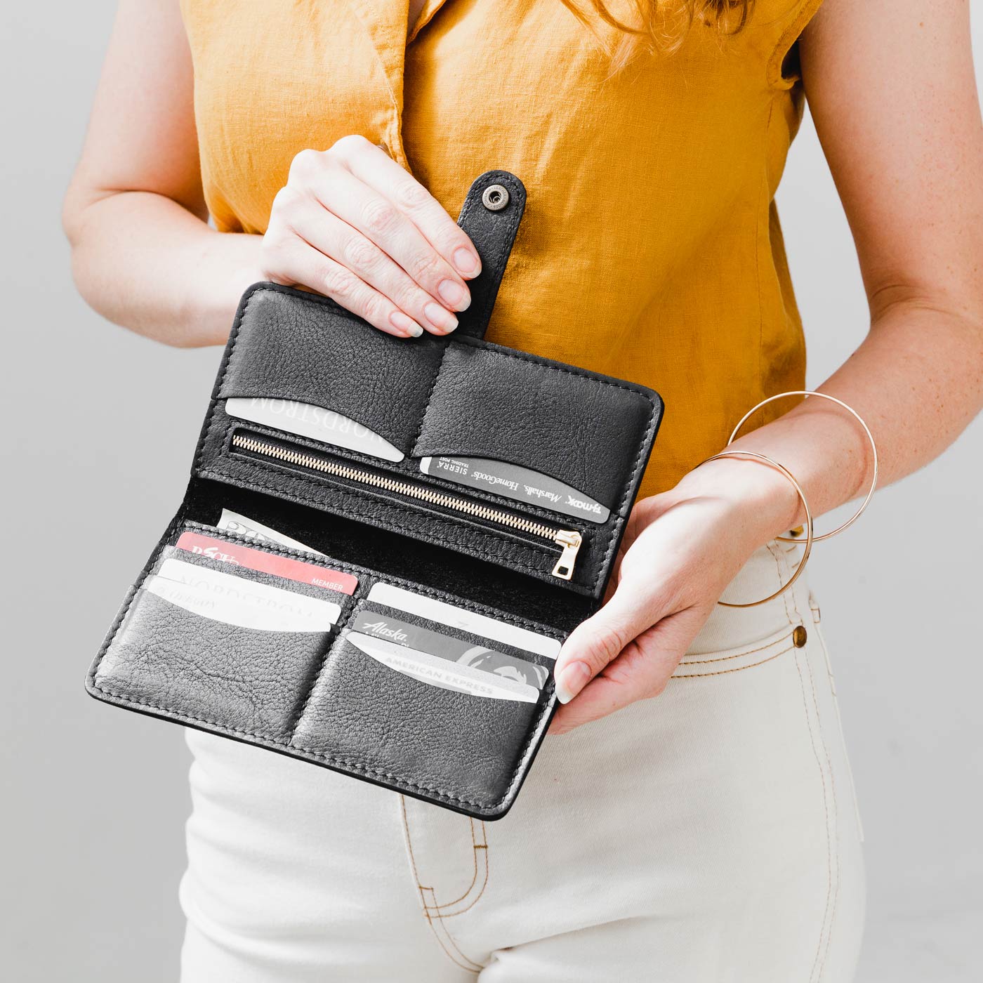 Pebbled--black | Model holding leather wallet with snap open